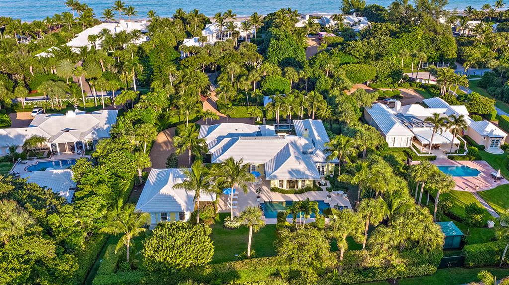 Sitting on almost one full acre and surrounded by a lush ficus hedge to ensure the utmost privacy, this beautifully designed and decorated Jupiter Island house with two separate guest cottages is the ultimate in gracious living. The main house features an enormous master bedroom with two master baths, expansive closets and serene views of an elegant reflecting pool/fountain. There are numerous entertaining spaces including a living room with a fireplace, latticed sunroom, formal dining room and enormous family room and kitchen. Each of the two guest houses has two bedrooms and a kitchen. Completely rebuilt from the ground up in 2008 with superb finishes including rare woods, elegant marble and impact windows. SEPARATE BACK ENTRANCE AND DEEDED BEACH ACCESS across the street.