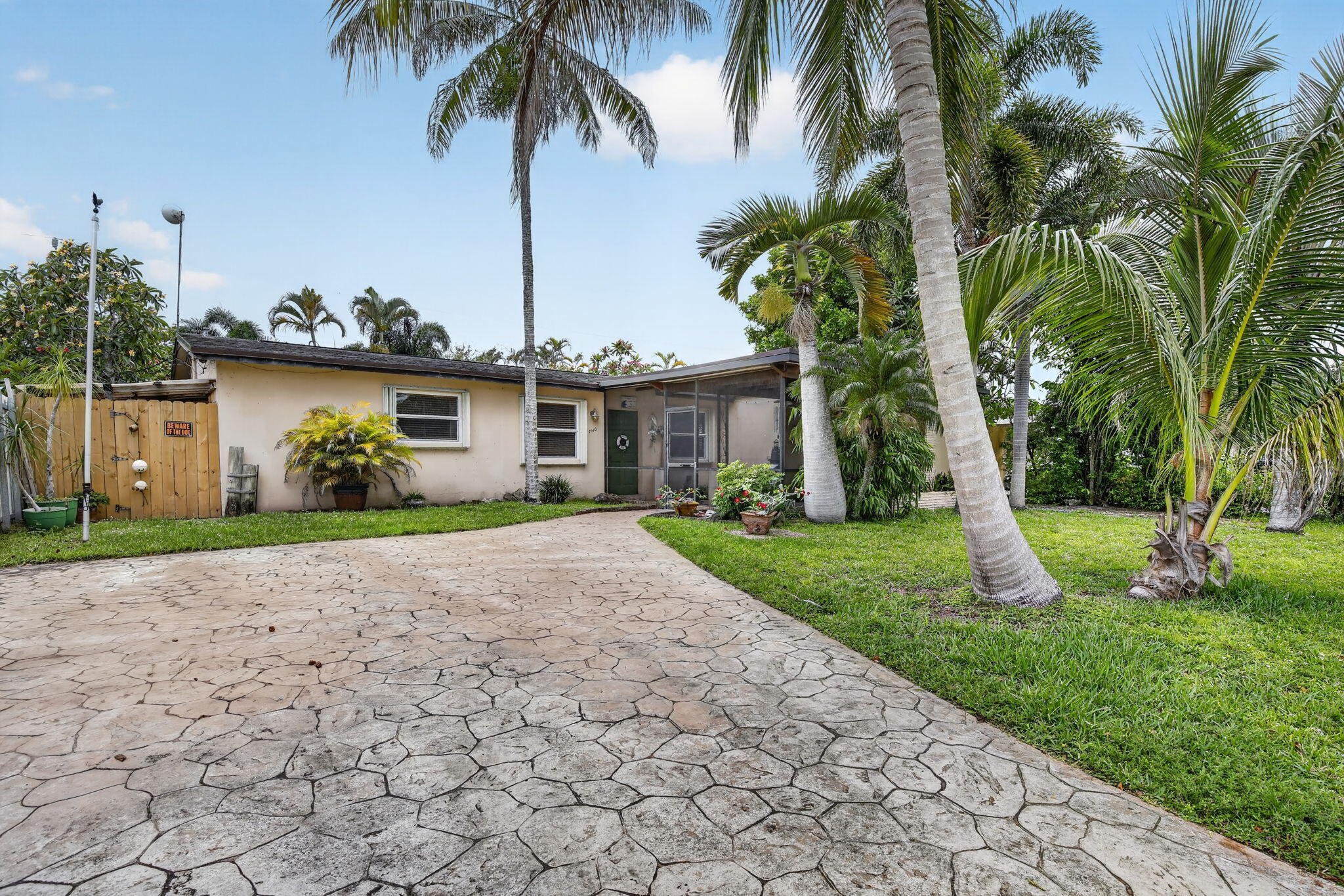 Welcome to this beautifully maintained South Florida pool home located in the heart of Hollywood with no HOA restrictions! Situated in a quiet, friendly community, this property offers the perfect combination of comfort, functionality, and resort-style outdoor living just 10 minutes from the beach.  Designed for seamless indoor-outdoor living, the home features a beautifully done pool patio with multiple sliding glass doors opening directly to the pool area, creating a bright and open atmosphere throughout the home. Both the front and back patios are screened, allowing you to fully enjoy the Florida lifestyle year-round. The primary suite offers direct pool access from the master bathroom, adding to the home's resort-like feel. Inside, the home showcases white tile floors and matching baseboards throughout, along with faux wood blinds in the living room and bedrooms for a clean and modern touch. The updated kitchen features elegant black marble countertops, white kitchen cabinets, a black refrigerator, and a sleek black and chrome glass-top stove, combining style and functionality for everyday living and entertaining.  The backyard oasis is truly special, featuring a sparkling pool with beautiful tile work and a stunning large dolphin tile insert. Additional upgrades include a new Hayward pool filter, automatic pool cleaner, whole-house water filtration system, and a water heater and A/C system that are still under warranty for added peace of mind. Roof has a 25 year warranty that is transferable to the new owners.  The property also includes new windows, accordion hurricane shutters, super gutters around the entire home, a stamped concrete driveway, and a 10 x 7 storage shed on a concrete slab in the backyard for extra storage and convenience.  The outdoor spaces are enhanced by unique water and fish garden features on both the back and front patios, creating a peaceful and relaxing atmosphere. With no HOA restrictions and an ideal layout for guests, this property would make an outstanding Airbnb, vacation retreat, investment property, or primary residence.  Conveniently located near beaches, shopping, dining, entertainment, and major roadways, this Hollywood gem offers the best of South Florida living with thoughtful upgrades and exceptional charm throughout!
