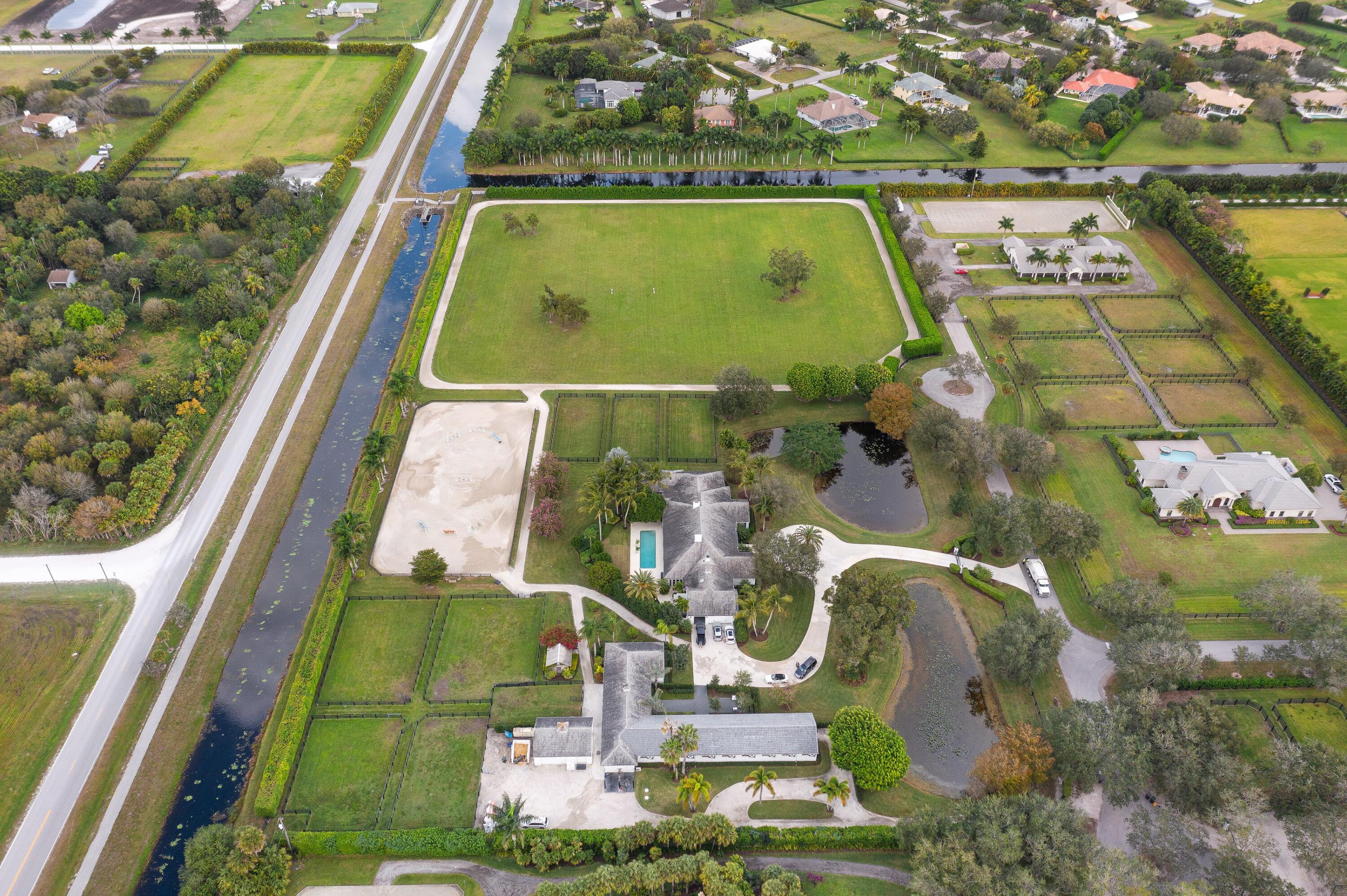 Magnificent 10-acre farm on the most private & prestigious street in Palm Beach Point. Located at the end of the cul-de-sac, this classic equestrian estate has recently been renovated & is move-in ready. Enjoy the sunsets from either the beautiful & spacious living room or outside on the patio or pool area.With one push of a button, the patio becomes a screened-in loggia.  Fireplaces in both the living room & family room warm this house up on the occasional cool winter season nights with options for formal dining or more casual get-togethers.  The spacious family room & cooks dream of a kitchen make entertaining a breeze. Oversized primary & guests bedrooms & bathrooms. Superb game room/tv room.  12-stall barn w/ staff living & storage. New Wordley-Martin ring, Grand Prix Field & track.