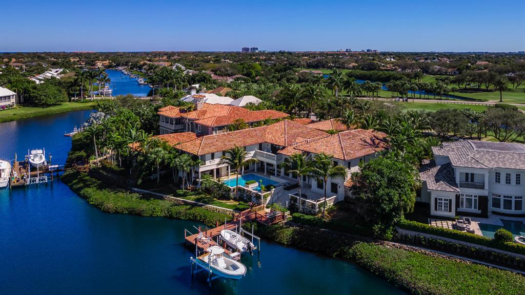 An estate of incomparable elegance. This  residence is situated on a half-acre-plus lot and overlooks the lush golf course and beautiful interior waterways of the much sought-after Admirals Cove.  Magnificent in scale and lavish in luxury, this property is created for living and entertaining on a grand scale.  Consisting of three wings with two elevators, this home features 7 bedrooms plus an office, 7 full and 2 half baths.  An elegant entryway leads to a formal living room with 24-foot wood beam ceilings, a fireplace, and expansive water views.  A formal dining room is adjacent to the massive gourmet chef's kitchen with dual 10-foot serving/seating islands, granite countertops, custom wood cabinetry, top-of-the-line appliances, commercial grade gas oven and cooktop, and so much more. and a butler's pantry.  An informal dining area, seating 20+, leads to a family room with paneled ceiling and a beautiful mahogany and granite bar.  Screen movies in your own theatre with popcorn bar, and store your prized wine collection in a custom wine cellar.  Enjoy working from home in your elegant office with custom mahogany built-ins.  Take a work-out break in your exercise room.  The first of two master en-suites features spectacular water views, multiple walk-in closets, a wet bar, and a spacious, elegant bathroom with double vanities, an oversized shower, and a jetted tub.  The second master suite adjoins a loft with gameroom, a large bunkroom for 4, and 2 additional en-suite bedrooms.  An oversized guest suite with separate entry includes a separate kitchenette.  This home was designed for outdoor entertaining, with extensive covered and open patio seating areas, a summer kitchen, gas grill, pizza oven, bar, dishwasher, and ice maker.  A lushly landscaped custom pool overlooks wide water views and a private dock and 2 lifts offer easy Intracoastal and Ocean access.