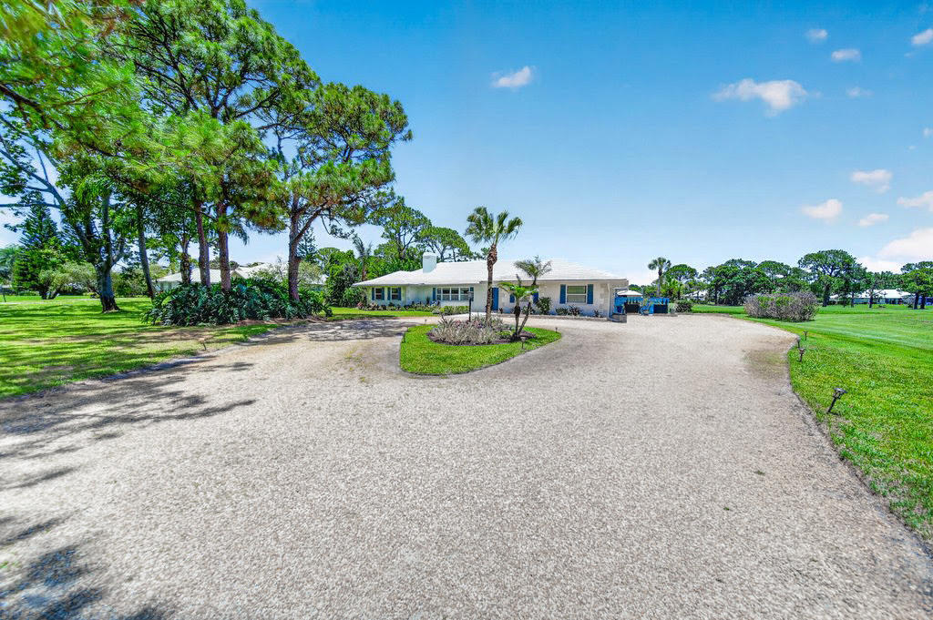 Experience relaxed Florida living in this light-filled 3BR/2BA CBS home situated on a PRIVATE ONE-ACRE LOT in the gated community of Evergreen. Circular driveway & lush tropical landscaping create an inviting first impression while peaceful GOLF COURSE VIEWS enhance the serene setting. The home features FULL IMPACT WINDOWS, porcelain flooring, neutral tones, spacious living areas & a desirable SPLIT FLOOR PLAN w/ large bedrooms throughout. Kitchen features Dekton quartz countertops, porcelain backsplash, WHITE CABINETRY & premium appliances. Spacious primary suite offers direct access to outdoor living spaces perfect for morning coffee or evening sunsets. Additional features include TANKLESS WATER HEATER & well-maintained finishes throughout.  Evergreen offers 24HR MANNED GUARD GATE, NO CLUB MEMBERSHIP REQUIRED (optional/play as you go). Located in the "A" rated Palm City school zone, minutes to I-95 & Turnpike, beaches, dining & downtown Stuart.