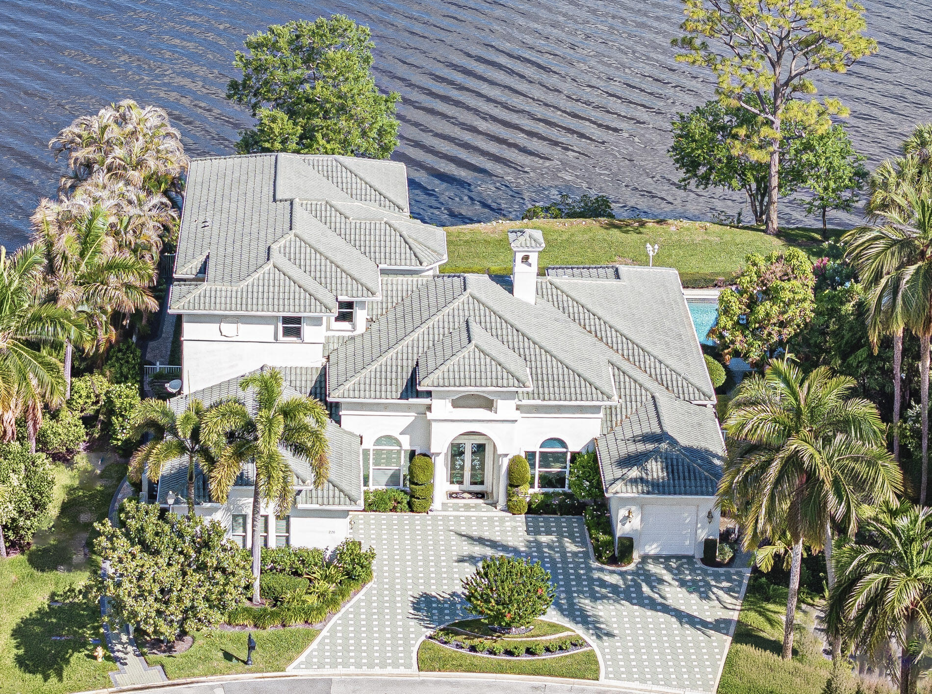 OFFERED FULLY FURNISHED & TURNKEY! Refined waterfront living w custom-built estate in Palm Cove premier yacht & golf club offering ocean access marina, championship golf, tennis, fitness, & social events. 5,300+ square living space & 137 ft of direct frontage on St. Lucie River. Breathtaking wide water views. 1st floor owner's suite w dual en-suite baths, fireplace, & elevator leading to 2nd-floor living area, deluxe billiards room, additional BRs & spacious balcony overlooking river. Updated kitchen is chef's dream w quartz countertops, premium gas Fulgor range & Sub-Zero fridge. Outside find a heated saltwater pool & spa, surrounded by lush landscaping. Built for peace of mind & convenience w impact glass, accordion shutters, a whole-house generator, & 3 A/C units plus split in garage. flooring & stunning custom glass entry doors. Separate garages complete w/ new cabinetry and epoxy floors. Paver circular driveway adds to homes impressive curb appeal. Offered fully furnished & turnkey.