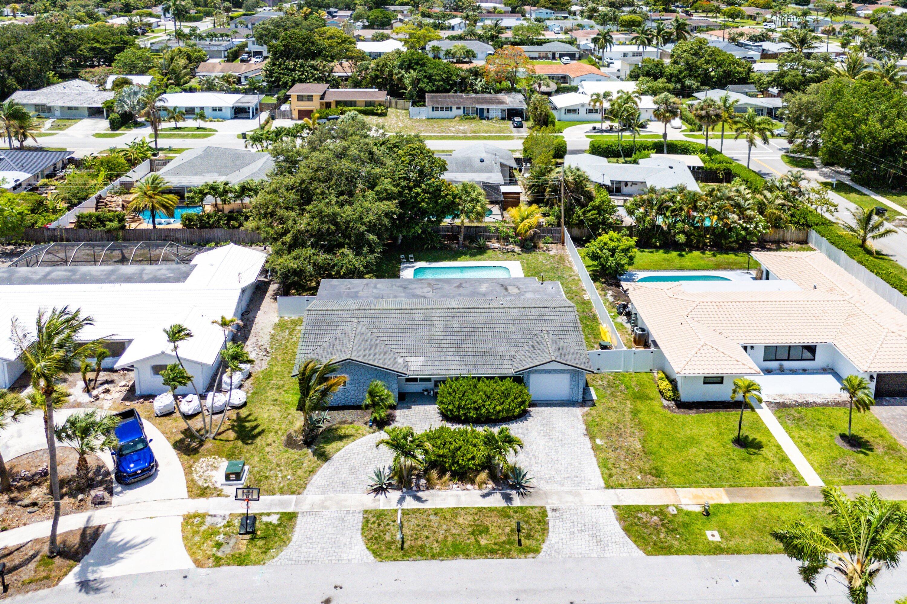 Nestled beneath a canopy of mature trees in one of Boca Raton's most sought-after neighborhoods, this beautifully updated 4-bedroom, 3-bath residence offers the perfect blend of comfort, style, and peace of mind. Light-filled living spaces feature oversized porcelain tile flooring, a renovated chef's kitchen with quartz countertops, custom cabinetry, and an open flow designed for both everyday living and entertaining. Recent improvements include fully renovated bathrooms (2024), impact windows and doors (2019), replacement of all cast iron plumbing, a tankless water heater, and newer appliances, allowing buyers to move in with confidence. Step outside to your private backyard retreat where a sparkling pool, expansive patio, lush landscaping, and magnificent shade trees create an ideal  setting for relaxing weekends, family gatherings, and outdoor entertaining. Located within the highly desirable Addison Mizner Elementary School district and just minutes from Boca's beautiful beaches, premier shopping, dining, parks, and places of worship, this home offers an exceptional East Boca lifestyle in a location that continues to be in high demand.