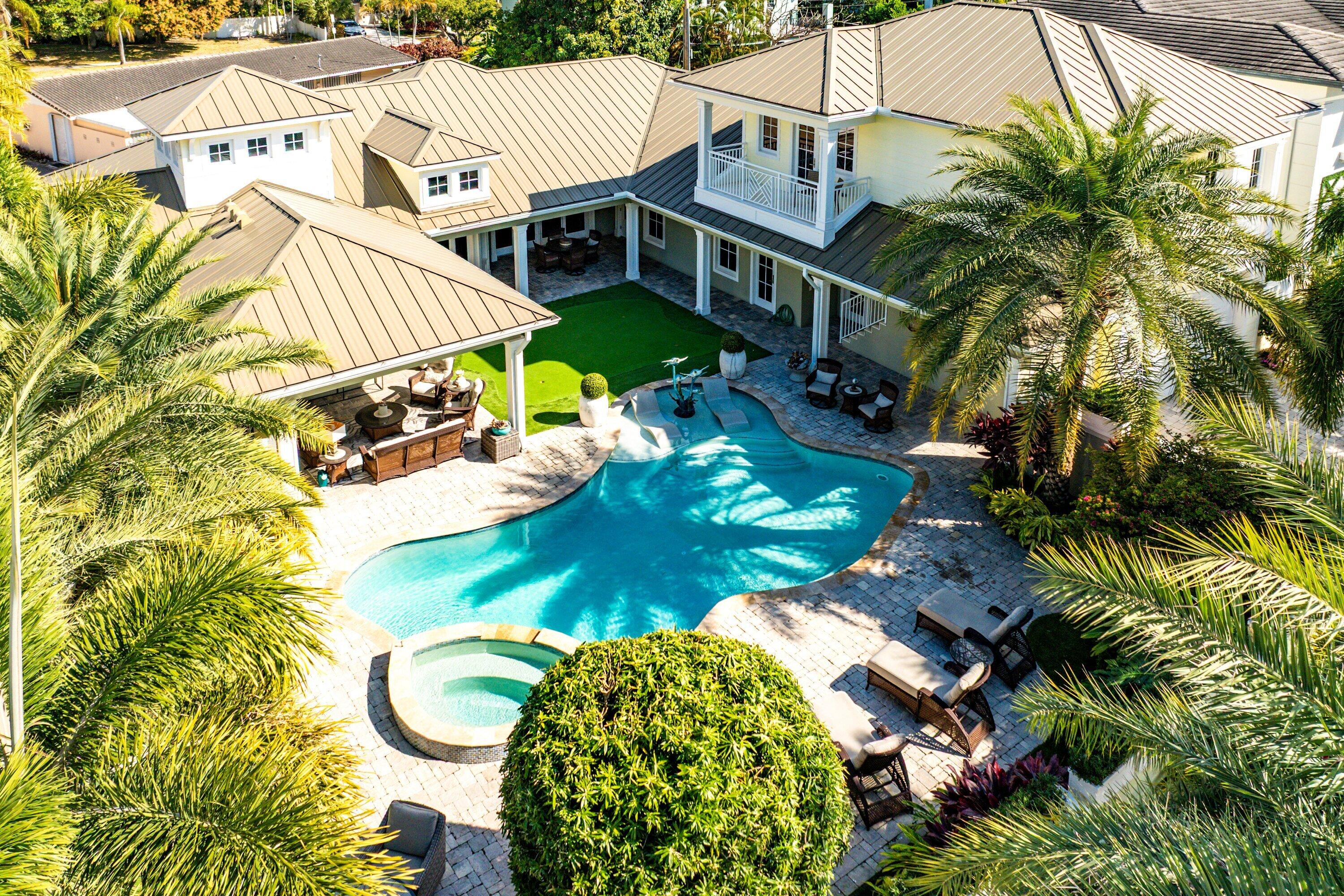 Stunning courtyard home in the heart of Boca Villas -- just steps to the beach, Mizner Park, Royal Palm Place, and the premier dining and boutiques along East Palmetto Park Road, as well as The Boca Raton -- this 2018 architectural residence offers a rare combination of walkability, privacy, and exceptional design. A striking entry introduces the home's defining statement: an expansive interior courtyard of remarkable scale and presence -- a private sanctuary that transforms everyday living into a resort-level experience. Anchored by a sparkling pool, the courtyard unfolds with a fully equipped summer kitchen, lush tropical landscaping, a private putting green, and a dedicated outdoor cabana bath. Grand yet intimate, this extraordinary outdoor environment is seamlessly integrated into the architecture of the home, creating an unparalleled setting for entertaining and year-round South Florida living. Courtyards of this magnitude and refinement are exceptionally rare in Boca Villas. Gracefully arranged around this central oasis, the guest quarters are separate in layout yet fully connected to the main residence, offering a full kitchen, living room, bedroom, and full bath -- providing privacy and flexibility while maintaining architectural cohesion. The main home offers three additional bedrooms, including a beautifully appointed office option, enhanced by refined ceiling details, generous storage throughout, and thoughtfully selected finishes. The primary suite is a true retreat, featuring separate his-and-her full baths and individual custom closets -- a rare and luxurious configuration that elevates both comfort and functionality. Crowned by a striking standing-seam metal roof, this 3,314-square-foot residence (5,015 total square feet) embodies timeless coastal architecture paired with modern craftsmanship. With 5 full baths and 2 half baths, this is not simply a home -- it is a one-of-a-kind courtyard estate in Boca Villas, where resort-style living meets one of Boca Raton's most coveted walkable locations.