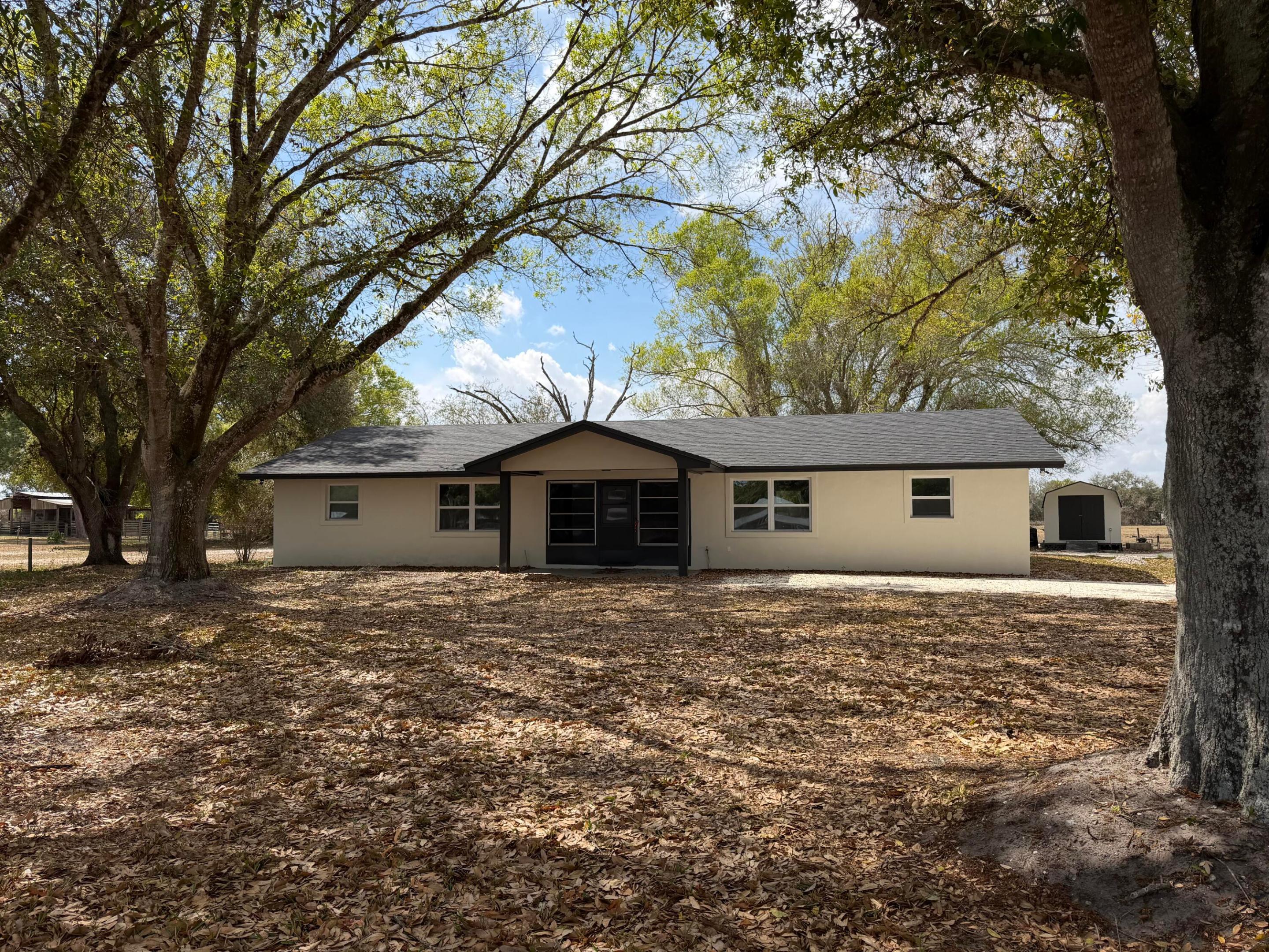 This fully upgraded CBS home offers 4 bedrooms and 2 full bathrooms, thoughtfully designed and currently configured as two separate 2 bed / 1 bath units. Zoned as a single-family residence, it's ideal for a large or multi-generational family while also offering excellent potential for rental income or private guest quarters. Step inside and you'll immediately notice the fresh, clean, modern finishes throughout. The home features: gorgeous large-format tile flooring with a sleek marble-look design, brand-new cabinetry and countertops in the kitchens, updated bathrooms with stylish vanities and fixtures bright, open living spaces with recessed lighting, fresh drywall and finishes throughout.  Major upgrades provide peace of mind, including: brand new roof, new A/C and new hot water heaters Each unit is designed for comfort and privacy, making it perfect for extended family living, hosting guests, or creating a flexible living arrangement. Outside, the property truly shines with 2.7 acres of land, giving you endless possibilities: Room for boats, RVs, or recreational toys Space to add a workshop, pool, or additional structures Ideal for those looking to grow, garden, or simply enjoy privacy and open space. The property also includes a detached shed, perfect for storage or hobbies, and is surrounded by mature trees offering shade and a peaceful setting. Whether you're looking for a spacious family home, a multi-generational setup, or a property with income-producing potential, this one checks all the boxes. Don't miss this rare opportunity to own a fully renovated, versatile home on acreage in Okeechobee!