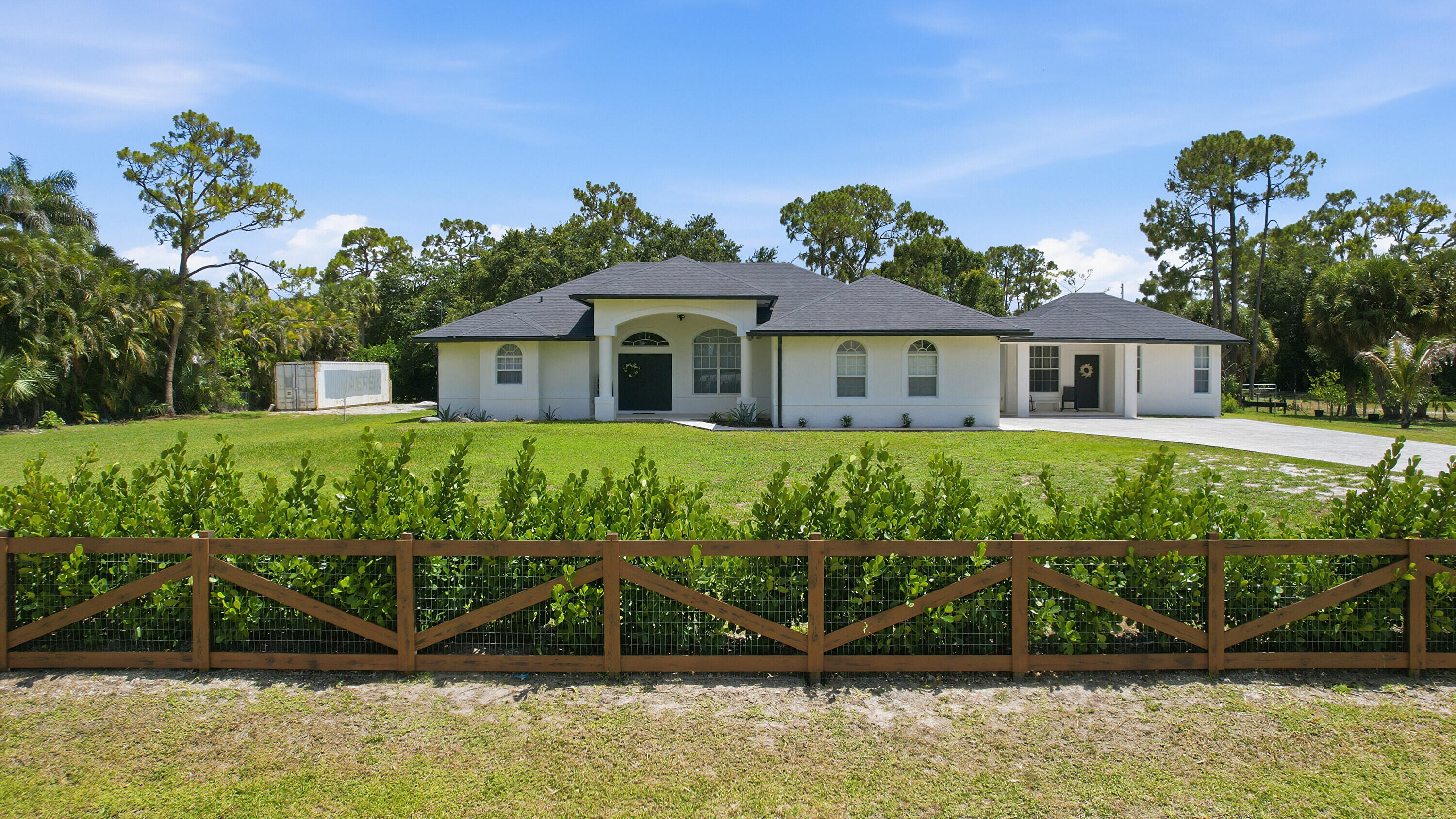 **UNIQUE PROPERTY ALERT!! 1.32 ACER CORNER LOT! GUEST HOUSE! FENCED! NO HOA! HIGH CEILINGS! NEW WATER FILTER SYSTEM! AND PLENTY OF SPACE FOR BIG TOYS!!** Experience the perfect blend of space, privacy, and versatility with this exceptional 5-bedroom, 3-bathroom single-family estate featuring a beautifully appointed guest house all situated on a fully fenced 1.32-acre corner lot. Located in one of palm beach's most desirable and secure NO-HOA. This Agricultural Residential- zoned property offers endless possibilities recreational vehicles, vegetable Garden, Chicken cup, future improvements and more! Inside, you'll find spacious living areas enhanced with soaring high ceilings and abundant natural light, along with a newly updated water filtration system, recessed lighting, and smart home accessories.  The property's beautifully appointed guest house includes a ready to use kitchenette—ideal for potential rental income opportunity. The exterior features a fully fenced yard with a motorized entrance gate, animal coop, mature oak and fruit trees, and a cozy bonfire area. There's also a large, compacted area ready for RV parking, boats, recreational vehicles and more. An existing storage container may also be included for an additional price. Conveniently located close to schools, parks, shopping, dining, and everyday conveniences. Don't miss this rare opportunity, schedule your private tour today and experience everything this incredible property has to offer!