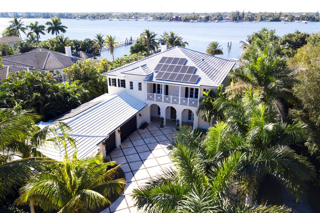 Spectacular custom built British West Indies Intracoastal Estate.  This four bedroom, four and one-half bath 9,291 SF home has top of the line finishes with special attention to detail, a three-car garage and guest house with self-contained living quarters.  Grounds feature sprawling water views with 102+/- feet of direct Intracoastal frontage, sparkling saltwater lap pool, two large covered patios for dining and living, fire pit, dock to accommodate a large boat, plenty of green space in both front and backyard and a very private walled and gated front yard.
Enter the home through the covered entryway into a foyer peering out through two-story living room onto the Intracoastal Waterway.  To the North of the foyer is an elegant spacious dining room perfect for entertaining guests and to the South is an office/library.  Just off the living room is a grand kitchen with a massive wood custom island.  The kitchen is adorned with Carrera Marble counter tops and marble backsplash equipped with custom cabinets, Thermador appliances, espresso machine, built-in wine racks, and two wine refrigerators. Kitchen opens into a cozy living room with pocket glass wall sliding doors that open up the room onto a patio bringing the outdoors inside.  There is also one waterfront guest suite on the main floor. 

Take the sweeping staircase or glass-windowed elevator up to the second floor and find a wrap-around gallery that overlooks the great room below, and leads into a loft-style second family room, 3 additional guest suites, and spacious master bedroom with all the amenities. Master bedroom overlooks the backyard and waterway with a balcony of it to enjoy the sunset views.  Master is equipped with a morning bar, additional laundry room, spa-like bath with massive shower and a large master closet with custom built-ins.

Hypoluxo community is nestled in the heart of Florida's Palm Beach County, tucked away between the Atlantic Ocean and the Intracoastal Waterway. A small town slightly less than one square mile in size, about a block from EAU Palm Beach Resort and Spa.  Even though its population barely exceeds 2,000 residents, Hypoluxo appeals to the person who enjoys solitude but also enjoys easy access to the range of entertainment, cultural and dining options of its neighboring towns. Within a short drive from Hypoluxo Island is the legendary island of Palm Beach, with world-famous Worth Avenue, offering an abundance of fine restaurants and boutiques, the international equestrian and polo community of Wellington as well as some of the finest golf courses in Palm Beach County. Hypoluxo is in close proximity to the following international airports: Palm Beach International, Fort Lauderdale International, Miami International.