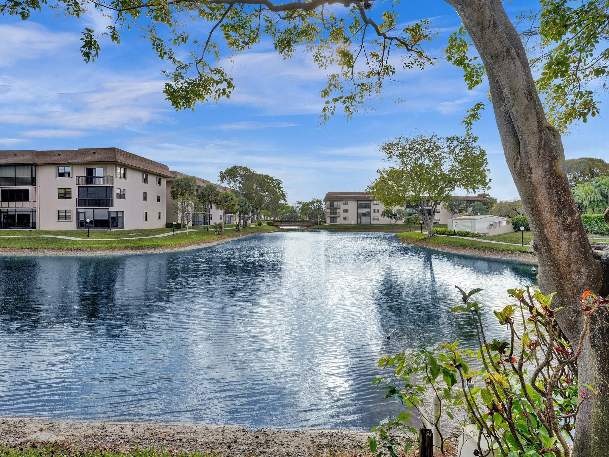 Experience this completely renovated, elegantly appointed condo offering serene and unobstructed water views. Designed with a sophisticated eye, this tastefully furnished home is truly move-in ready—simply arrive with your personal belongings and begin enjoying a turnkey 55+ lifestyle. Every detail has been thoughtfully curated to reflect both comfort and style, with interiors that mirror the quality and beauty seen in the photos. Ideally positioned just steps from the resort-style pool and clubhouse, residents enjoy effortless access to a full suite of premium amenities. Begin your day with coffee on the private, fully furnished patio overlooking tranquil waters. The Bldg. shows new ROOF and ELEVATOR. Internet and cable included.