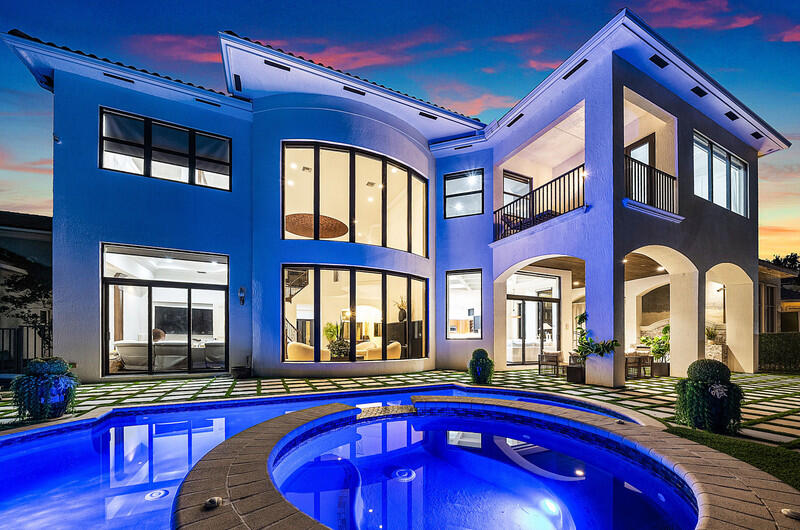 Presenting one of the most exceptional offerings within The Oaks at Boca Raton, the coveted Dominique model is celebrated for its grand scale, timeless architecture, and unparalleled livability. Masterfully reimagined by a licensed master luxury builder with uncompromising attention to detail, this extraordinary estate showcases designer finishes, state-of-the-art upgrades, and a level of craftsmanship rarely seen in today's market. Designed for both elevated entertaining and effortless everyday living, the residence has undergone a comprehensive top-to-bottom renovation with no expense spared.  Significant capital improvements provide both luxury and peace of mind, including hurricane-impact windows and doors, new roof in 2026, and a fully customized outdoor living experience, new marble paver driveway, gutters and so much more. The backyard has been transformed into a private resort-inspired retreat. A completely renovated pool and patio feature a new Diamond Brite finish and designer tile, porcelain pavers, refined turf landscaping, and a custom-built outdoor kitchen with integrated grilling station—creating the ultimate setting for sophisticated entertaining or tranquil relaxation. Inside, every detail has been thoughtfully curated. The newly designed chef's kitchen is a true showpiece, featuring custom cabinetry, premium appliances, a French-door Viking oven, and a bespoke built-in banquet seating area that seamlessly blends warmth and functionality. Elegant custom wall paneling, designer wall coverings, blackout shades, decorative plaster detailing, and grand statement chandeliers elevate the interiors throughout. A dramatic custom staircase serves as a striking architectural centerpiece, leading to a state-of-the-art home theater complete with immersive twilight ceiling design for an unparalleled cinematic experience. The enhanced floor plan offers expansive living spaces flooded with natural light, while Tier 1 Select & Better engineered hardwood flooring and fully redesigned spa-inspired bathrooms further reflect the home's refined aesthetic. Mahagony elevator located adjacent to the laundry up and laundry down enhances the functionality of the home with easy living.  Residents of The Oaks at Boca Raton enjoy an unrivaled country club lifestyle centered around a magnificent clubhouse with fine dining, resort-style spa services, a state-of-the-art fitness center, and one of Boca Raton's premier tennis and pickleball programs featuring Har-Tru clay courts, professional instruction, leagues, and vibrant social events. This is a rare opportunity to acquire one of The Oaks' signature estates—where scale, sophistication, and luxury living converge in one of Boca Raton's most prestigious gated communities.