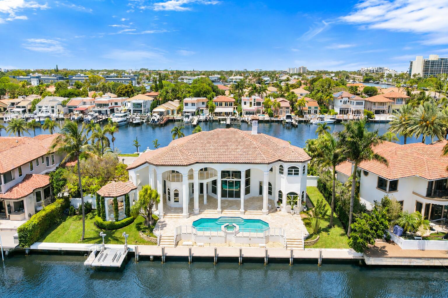 Experience waterfront living at its finest in this beautifully reimagined custom estate in Tropic Isle South, one of Boca Raton's most exclusive gated enclaves. Perfectly positioned on a rare double waterfront lot with 300 feet of deepwater frontage- 150 feet on each side of the property- and including a brand new seawall on the north side, this residence captures sweeping and grand canal views from every room. This home will feature a brand-new designer kitchen with dual islands, a walk-in pantry, and top-of-the-line Miele and GE monogram appliances, creating the ultimate culinary haven.  The impressive open layout is complemented with all new Hurricane impact windows and sliders, soaring ceilings and custom architectural details that flood the interiors with natural light. Each of the 4 spacious bedrooms is en-suite, complete with its own private bath and closet. The home offers two luxurious primary suites--one on the main level and another upstairs--ideal for multi-generational living or guest accommodations.  Step outside to enjoy extensive outdoor living spaces, including a covered patio, a fully equipped summer kitchen, two covered balconies, and a gazebo overlooking the water. A 3-car garage provides ample parking and storage, perfectly complementing the home's thoughtful design and functionality.  Located minutes from vibrant dining and shopping in Downtown Boca Raton and Delray Beach, this one-of-a-kind property offers the best of South Florida's luxury living. Expected completion April of this year.