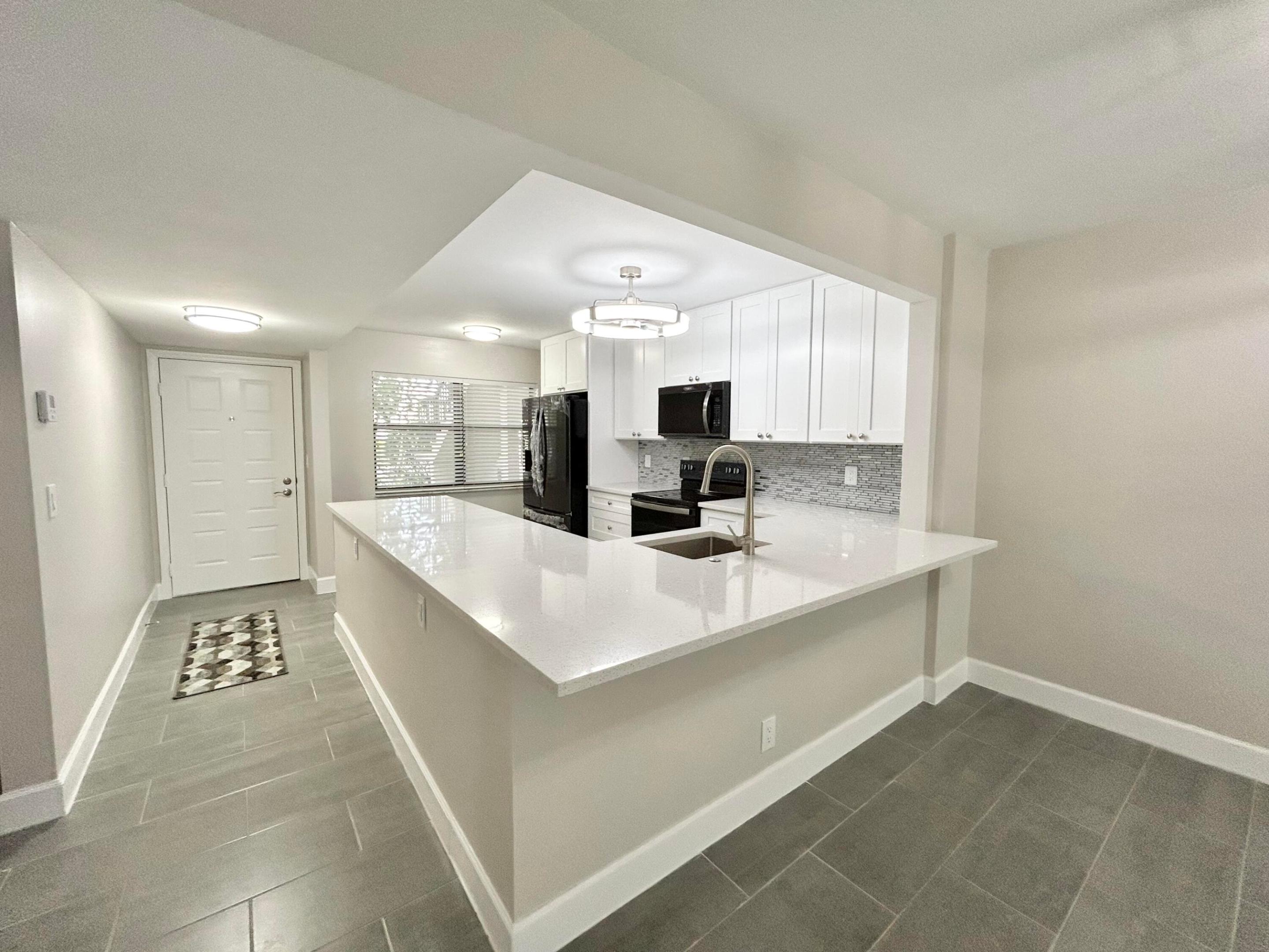 Completely and Beautifully renovated with open floor plan complete w breakfast bar, 42" solid wood white shaker cabinets, quartz counter tops, deep single sink w disposal. Black stainless steel appliances include filtered water, ice maker, electric range w air fryer, dishwasher with stainless steel tub. LED light fixtures throughout and remote control fans with LED lights. Full sized washer and dryer inside the property. Split floor plan provides privacy from guests. Master bedroom offers ensuite bathroom w tiled walk in shower and large walk in closet. Sliding glass doors lead to enclosed porch overlooking private beautiful garden area. Walk in large storage closet on porch. New electric panel and hot water tank.  Community offers resort features including olympic sized heated swimming pool and satelite pool w hot tub, whirl pool, sauna, showers, lockers and changing rooms,  large clubhouse and auditorium/theater, 2 fitness rooms, library, billiards, tennis/pickleball courts, sidewalks and street lights. Service and emotional animals welcome. Association requires 750 credit score for all buyers. Conveniently located near Floridas turnpike for easy travel distance to casinos, Atlantic Avenue restaurants and nightlife, City place, golf courses and public parks. Close to beaches, medical and shopping.