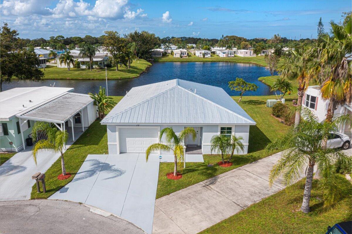 Spanish Lakes Riverfront offers the perfect blend of lifestyle and value in a vibrant 55+ community. Enjoy FREE golf on the Par 3, 9-hole course—an incredible perk for active living! Located on a quiet cul-de-sac, this pristine, move-in ready CBS home showcases beautiful lake views and a bright, inviting layout. Featuring 2 bedrooms (with the second bedroom offering pocket doors for added flexibility), 1.5 baths, and a 1-car garage, this home is designed for both comfort and convenience. Upgrades include a metal roof, impact-resistant windows, stainless steel appliances, granite countertops, elegant Hunter Douglas shades, a newer refrigerator, upgraded toilets, a tankless water heater, and a dedicated A/C closet in the garage. Enjoy peace of mind w/multiple warranties: Carrier A/C (10-year parts), CGI Sparta impact windows (limited lifetime), Gulf Coast metal roof (25-year), Hunter Douglas blinds (lifetime), Gerber toilet (5-year), Moen faucets (limited lifetime), and Hurricane Master garage door (limited warranty). A fire alarm system is also in place for added safety. Relax on your screened patio overlooking the water—your own private retreat. Residents enjoy resort-style amenities included in the land lease (no HOA fees), featuring heated pools and hot tubs, a grand clubhouse, fitness center with sauna, library, lounge with bar, card rooms, tennis, pickleball, shuffleboard, bocce, fishing, plus river access with boat ramp, dock, and optional RV/boat storage. This is a fantastic opportunity to enjoy peaceful lakefront living while embracing an active, low-maintenance lifestyle in one of the area's most desirable 55+ communities. Come experience the charm of Spanish Lakes Riverfront and start your next chapter today!