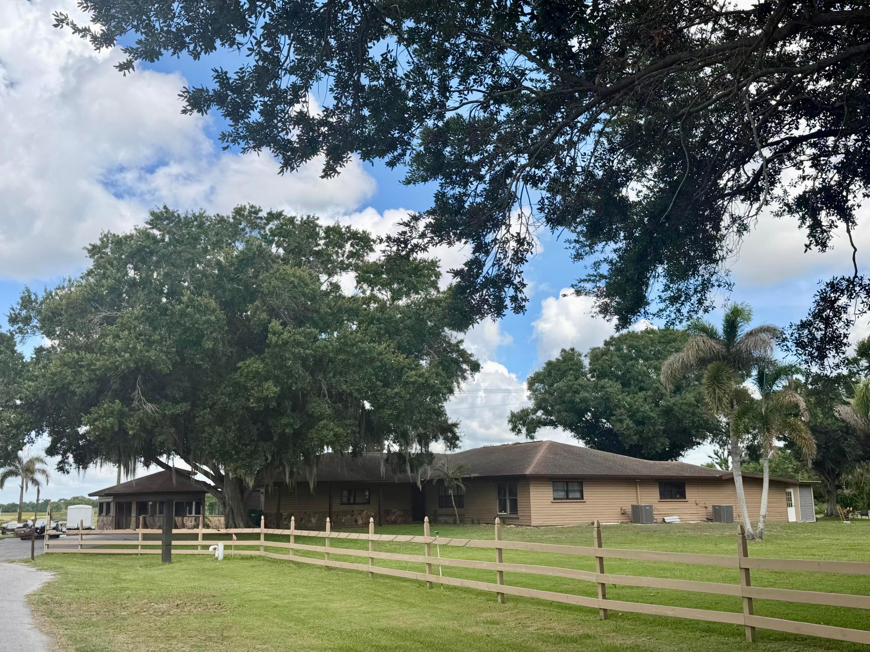 Experience the ultimate Old Florida waterfront lifestyle on scenic Taylor Creek with direct access to world-famous Lake Okeechobee. Situated on 1.13 beautifully landscaped acres, this extensively remodeled estate is designed for entertaining, relaxation, and unforgettable gatherings. The spacious residence offers multiple living areas including 2 large family/living rooms and an impressive full-scale game room perfect for hosting guests year-round. Outdoor amenities are second to none with 2 private boat slips, private boat ramp, expansive dock, waterfront cabin, and exceptional boating access for fishing and lake adventures. Enjoy your own professional putting green surrounded by lush tropical landscaping highlighted by stunning mature Foxtail Palms. Additional features include a detached building ideal for a private office, guest quarters, or in-law suite, plus an extra workshop with concrete pad for storage, hobbies, or equipment. Whether you are searching for a luxury waterfront retreat, seasonal winter escape, corporate getaway, or exceptional income-producing property, this rare Taylor Creek compound delivers endless possibilities in a truly one-of-a-kind setting.