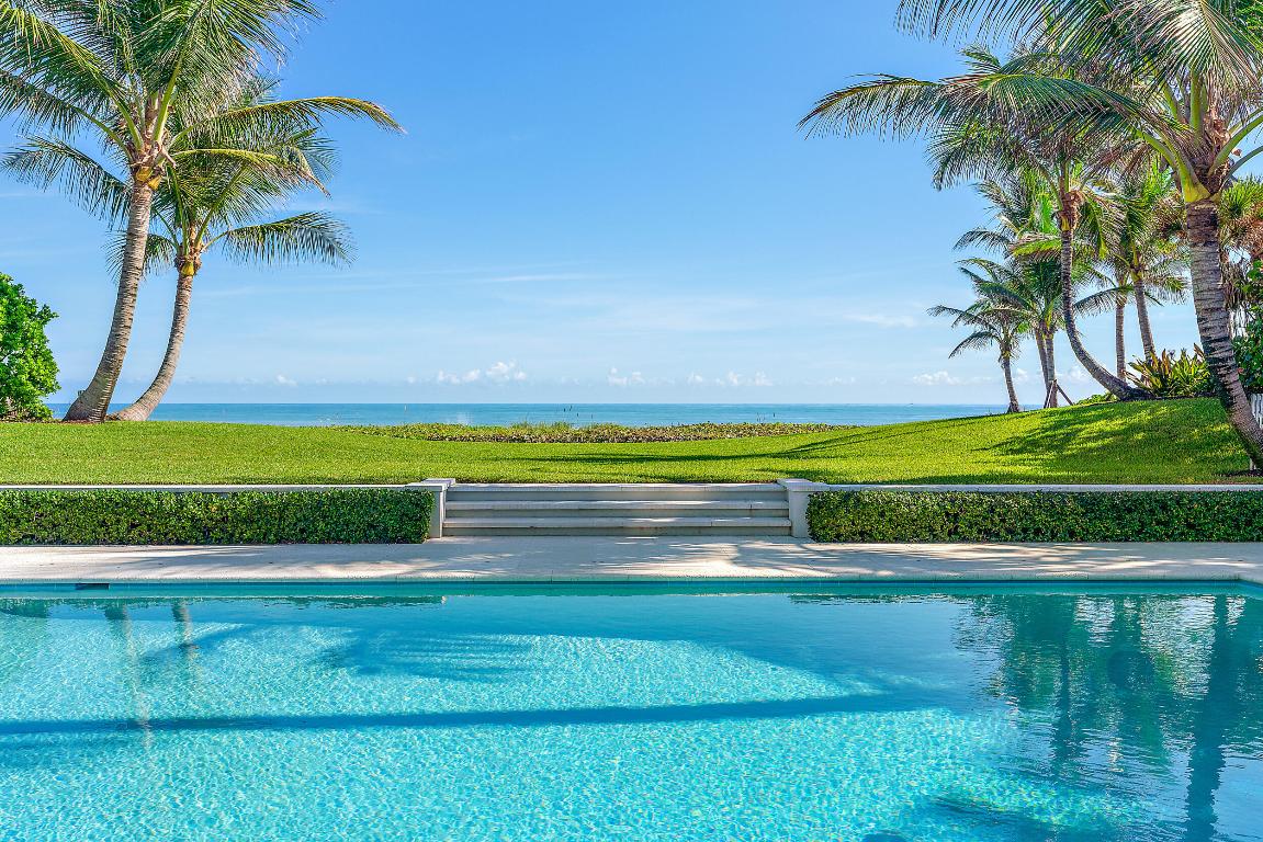 This fabulous 1.53 acre oceanfront property with a high elevation sits directly on 200' of prime Jupiter Island beach. In addition to the main house, there are two guest houses each with two bedrooms and baths, separate kitchens and living rooms which can easily accommodate a large family and guests while allowing complete privacy for all. Redesigned and renovated in 2017 to feature a desirable open plan, this family compound includes a beautiful pool area with ample space to swim, dine and sun bathe. If you prefer to relax in the shade, there is a louvered pergola controlled by remote. An outdoor kitchen for alfresco entertaining includes a gas grill, cook top, refrigerator and sink completes this tropical oasis. Please note some photos are virtually staged.