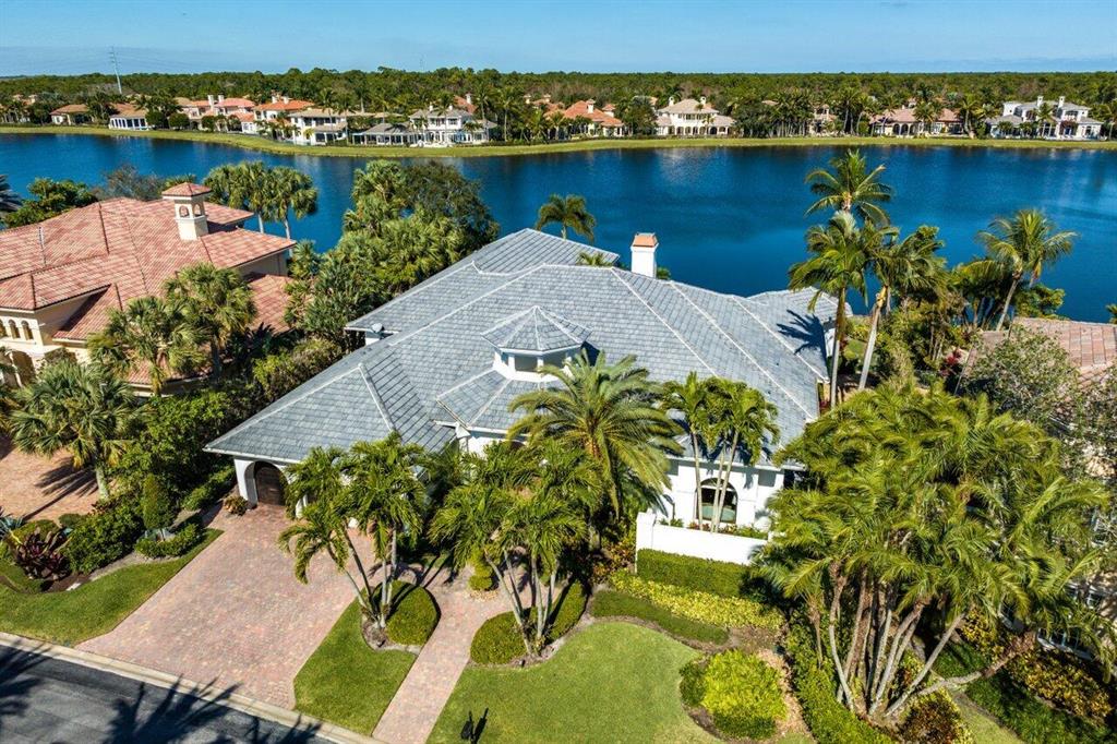 Stunning lake views for this light and bright custom estate home! Coveted golf membership and situated on a wide water lot in The Club at Mirasol. Step into the light and bright foyer that leads to the living room with gorgeous lake and pool views. This home offers over 5800 living square feet, 4bed/4.5 baths, office, and theater room all on one level. The redesigned gourmet kitchen boasts marble countertops, Miele appliances, built in coffee maker, Swarovski crystal hardware, wine fridge, and so much more. The backyard oasis is perfect for entertaining with summer kitchen, sparkling resort style flagstone pool & spa with water features, panoramic serene lake views, and more. Other features include newer roof, complete hurricane protection, artificial turf, wet bar, and freshly painted exterior. Call for your private tour today!