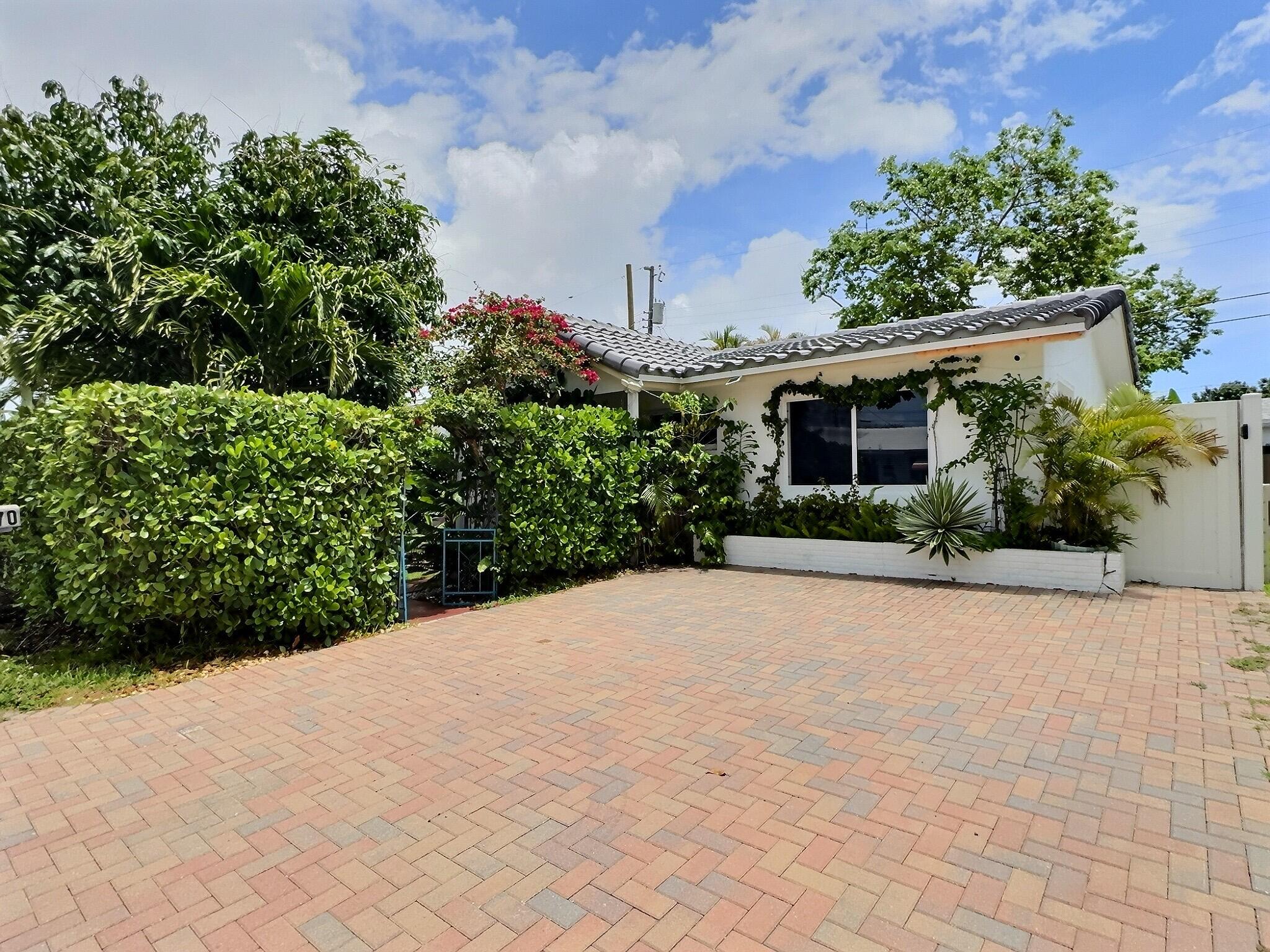 Tropical garden retreat in Tamarac Lakes! This 2BR/2BA single-family home is surrounded by lush, fenced-in landscaping lovingly created by the owner, featuring mango, banana, pear, guayaba trees and colorful bougainvilleas. Big-ticket updates include a concrete barrel tile roof replaced in 2025, impact windows and A/C 2022. Enjoy an expanded paver driveway for 2 cars, private front porch and screened rear patio overlooking the gardens. Interior is ready for your personal touch, with virtually staged photos showing design possibilities. Community amenities include clubhouse, large waterfront pool, shuffleboard and picnic area. A wonderful opportunity to make it your own!