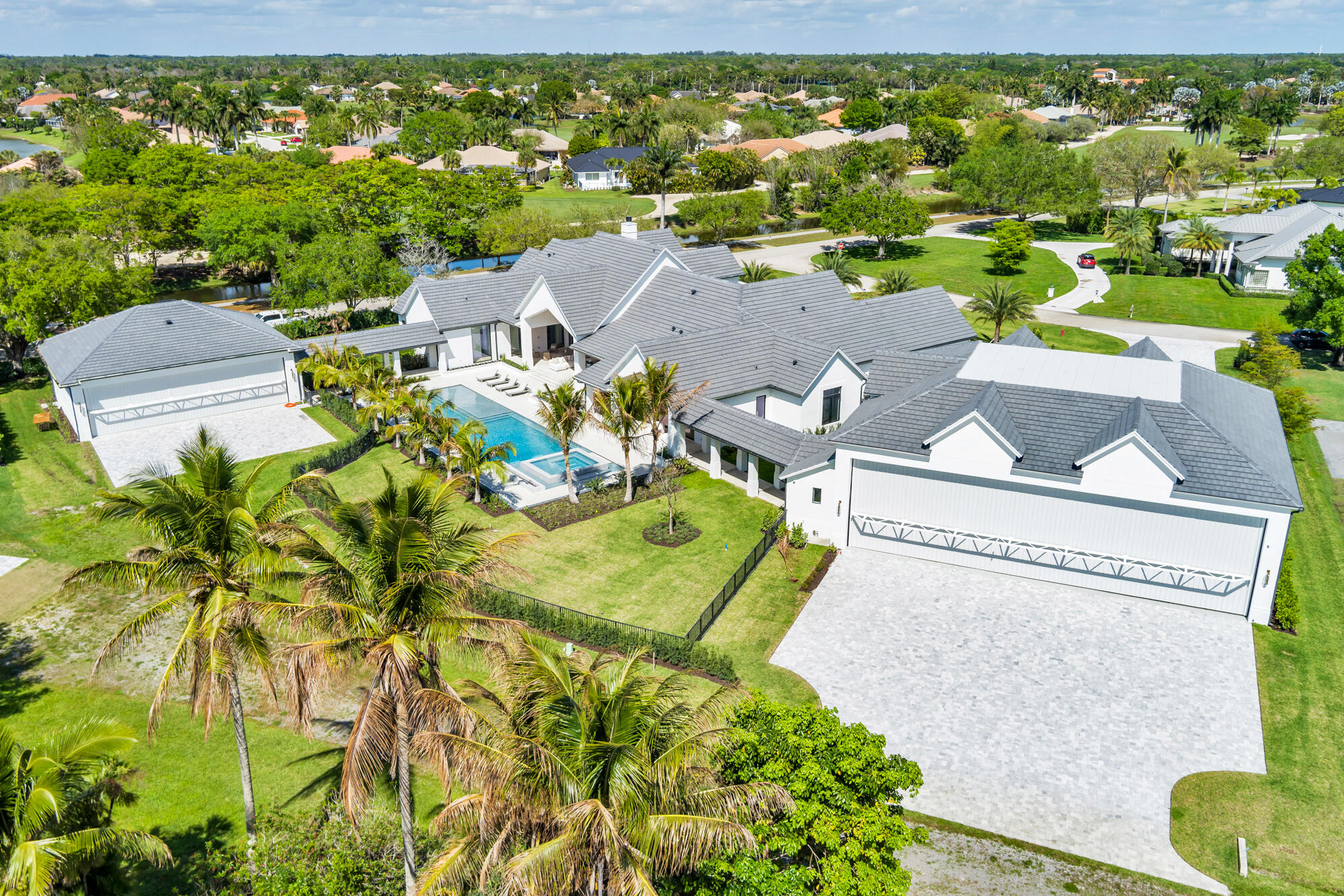 The most anticipated home in Aero Club has arrived. Designed by Diaz & Lang with interiors by HW Interiors, this custom 5 Bed 6.2 Bath estate sits on a lot and a half and has just been completed, ready for its first owner.  Aero Club is one of South Florida's most coveted addresses, an aviation community unlike any other with its own private runway. This property delivers on every level: 8,400+/- sq ft under air across the main residence, a 70'x60' (4,400+/- sq ft) primary epoxy hangar, and a third structure with an additional 2,000+/- sq ft of epoxy hangar space all attached to the main home via covered breezeway.  The kitchen features a custom fluted pill-shaped oak island accompanied by a Wolf six-burner cooktop with griddle, Wolf double oven and warming drawer, Sub-Zero panel-ready  refrigerator and freezer, and a Bosch panel-ready dishwasher, stone backsplash with an in-wall sliding niche for spice storage, pot filler, and concrete pendant lighting overhead. The island features pop-up outlets and touch-latch cabinetry for ample storage. The hidden pantry features a second dishwasher, Wolf microwave and warming drawer, GE panel-ready ice maker, sub zero fridge and freezer, laundry sink and additional cabinetry.   The great room fireplace is flanked by floor-to-ceiling white concave wood fluting, built-ins with fluted wood backing and floating shelves, aged brass sconce lighting, and a herringbone brick firebox framed in mitered-edge stone. Warm, architectural, and entirely custom.  The wine pantry features a Sub-Zero fridge, stone bookmatched back wall, floating white oak shelves, and fluted cabinetry with touch-latch doors making this a showcase for any wine collection.  The primary suite bathroom is one of many jaw-dropping spaces in the home. A solid concrete 72" soaking tub, floor-to-ceiling honed marble shower, sinks with brushed brass custom stone handles, mosaic flooring throughout, a custom stone-trimmed mirror, and a full thermostatic, waterfall, and handheld shower system. Every detail was chosen with intention.  Each additional bathroom carries its own character — Calacatta gold marble and a designer tub in Bath 1, penny round matte white flooring and a two-inch stone countertop in Bath 2, Moroccan mosaic tile and a custom integrated stone vessel sink in the powder bath, and a green absinthe trapezoid tile with vintage brass fixtures in the cabana bath. No two bathrooms feel the same.  The dedicated fitness room pairs with a full steam suite featuring a Thermasol touch control system with Bluetooth capability, a Brizo Odin thermostatic shower system, and floor-to-ceiling stone across walls, floors, and ceiling. The playroom/office features a 141-inch built-in desk, cork board, and custom rift-cut white oak cabinetry. Upstairs, a second bar with Sub-Zero fridge, GE nugget ice maker, and Wolf microwave keeps the second level stacked for those perfect movie nights or hangouts.  Outside, the summer kitchen is built around a Piasentina sapiens stone waterfall countertop, Wolf outdoor grill, two Wolf built-in burners, and a Sub-Zero panel-ready refrigerator — all under a Tradewinds outdoor hood. The heated/chilled saltwater pool & spa are surrounded by covered outdoor living areas which make this backyard perfect for year round swimming and entertainment. The backyard faces due west which provides picturesque sunsets.  Homes finished to this level do not come around often. This estate is ready for occupancy!  Aero Club is located just minutes away from the Winter Equestrian Festival. Wellington Aero Club is a private aeronautical community located in Wellington, Florida. It features 240 custom-built homes on one-acre lots, many with private hangars, and a lighted and paved 4,000 foot runway. There is also AV Gas available directly at the airport.