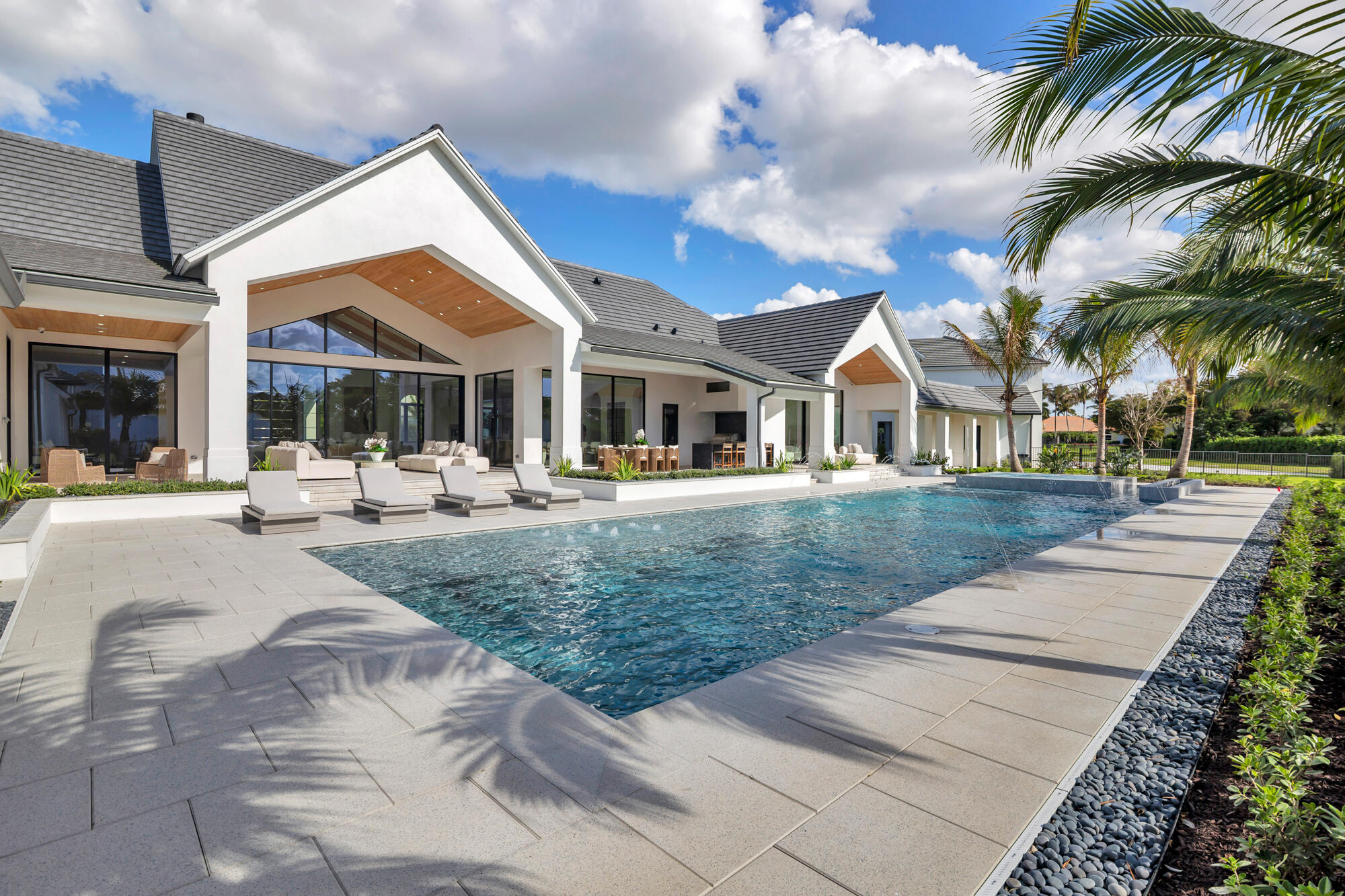 The most anticipated home in Aero Club has arrived. Designed by Diaz & Lang with interiors by HW Interiors, this custom 5 Bed 6.2 Bath estate sits on a lot and a half and has just been completed, ready for its first owner.  Aero Club is one of South Florida's most coveted addresses, an aviation community unlike any other with its own private runway. This property delivers on every level: 8,400+/- sq ft under air across the main residence, a 70'x60' (4,400+/- sq ft) primary epoxy hangar, and a third structure with an additional 2,000+/- sq ft of epoxy hangar space all attached to the main home via covered breezeway.  The kitchen features a custom fluted pill-shaped oak island accompanied by a Wolf six-burner cooktop with griddle, Wolf double oven and warming drawer, Sub-Zero panel-ready  refrigerator and freezer, and a Bosch panel-ready dishwasher, stone backsplash with an in-wall sliding niche for spice storage, pot filler, and concrete pendant lighting overhead. The island features pop-up outlets and touch-latch cabinetry for ample storage. The hidden pantry features a second dishwasher, Wolf microwave and warming drawer, GE panel-ready ice maker, sub zero fridge and freezer, laundry sink and additional cabinetry.   The great room fireplace is flanked by floor-to-ceiling white concave wood fluting, built-ins with fluted wood backing and floating shelves, aged brass sconce lighting, and a herringbone brick firebox framed in mitered-edge stone. Warm, architectural, and entirely custom.  The wine pantry features a Sub-Zero fridge, stone bookmatched back wall, floating white oak shelves, and fluted cabinetry with touch-latch doors making this a showcase for any wine collection.  The primary suite bathroom is one of many jaw-dropping spaces in the home. A solid concrete 72" soaking tub, floor-to-ceiling honed marble shower, sinks with brushed brass custom stone handles, mosaic flooring throughout, a custom stone-trimmed mirror, and a full thermostatic, waterfall, and handheld shower system. Every detail was chosen with intention.  Each additional bathroom carries its own character — Calacatta gold marble and a designer tub in Bath 1, penny round matte white flooring and a two-inch stone countertop in Bath 2, Moroccan mosaic tile and a custom integrated stone vessel sink in the powder bath, and a green absinthe trapezoid tile with vintage brass fixtures in the cabana bath. No two bathrooms feel the same.  The dedicated fitness room pairs with a full steam suite featuring a Thermasol touch control system with Bluetooth capability, a Brizo Odin thermostatic shower system, and floor-to-ceiling stone across walls, floors, and ceiling. The playroom/office features a 141-inch built-in desk, cork board, and custom rift-cut white oak cabinetry. Upstairs, a second bar with Sub-Zero fridge, GE nugget ice maker, and Wolf microwave keeps the second level stacked for those perfect movie nights or hangouts.  Outside, the summer kitchen is built around a Piasentina sapiens stone waterfall countertop, Wolf outdoor grill, two Wolf built-in burners, and a Sub-Zero panel-ready refrigerator — all under a Tradewinds outdoor hood. The heated/chilled saltwater pool & spa are surrounded by covered outdoor living areas which make this backyard perfect for year round swimming and entertainment. The backyard faces due west which provides picturesque sunsets.  Homes finished to this level do not come around often. This estate is ready for occupancy!  Aero Club is located just minutes away from the Winter Equestrian Festival. Wellington Aero Club is a private aeronautical community located in Wellington, Florida. It features 240 custom-built homes on one-acre lots, many with private hangars, and a lighted and paved 4,000 foot runway. There is also AV Gas available directly at the airport.