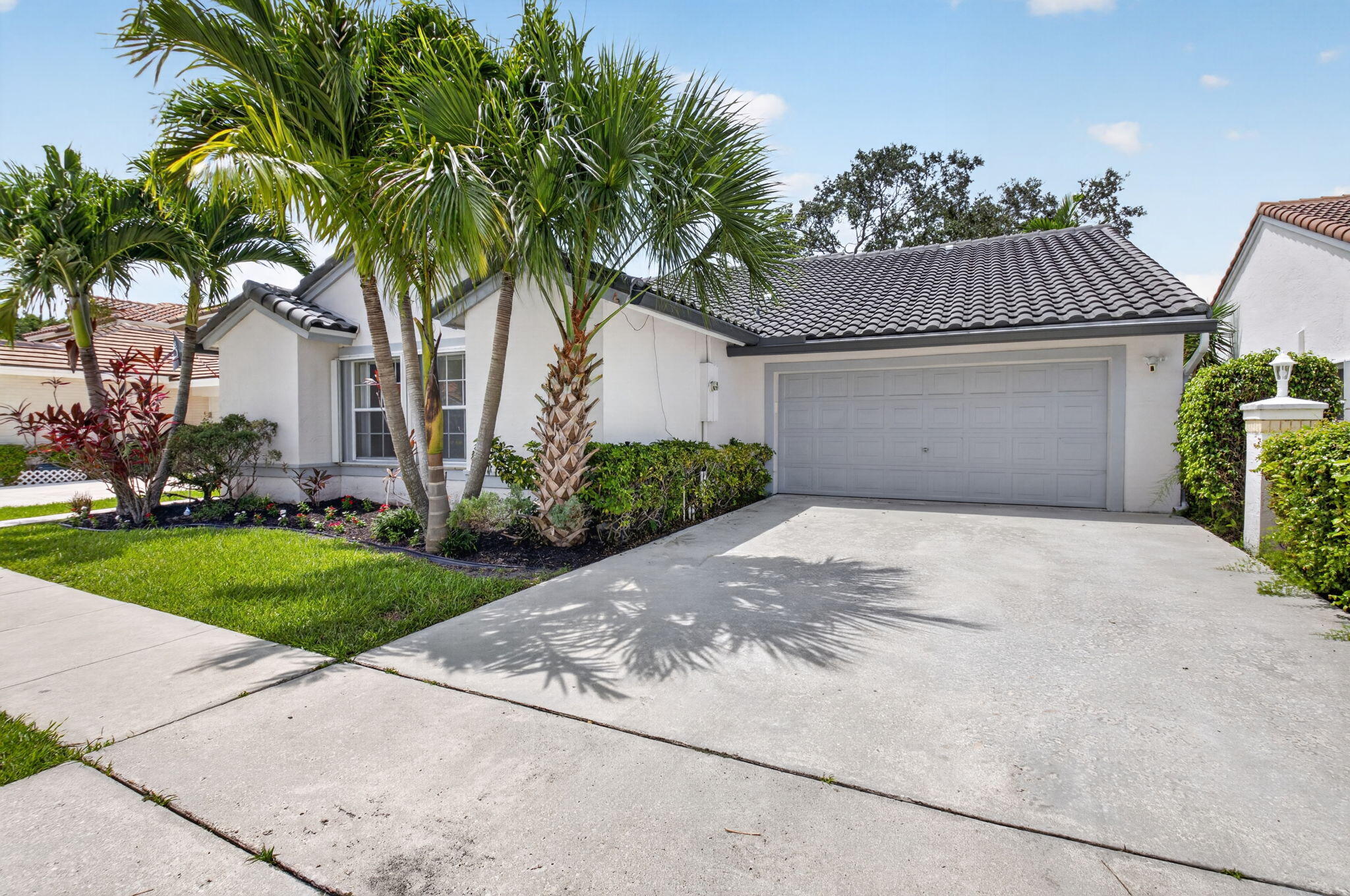 Welcome to 10048 Country Brook Road, a charming single-story waterfront home in the desirable Boca Springs community of Boca Raton. This 3-bedroom, 2-bath residence offers 1,922 square feet of comfortable living space, a 2-car garage, and a bright, open layout with vaulted ceilings and generous natural light. The main living areas feature neutral tile flooring and a spacious flow ideal for everyday living or entertaining. The primary suite offers excellent space, a large walk-in closet, dual-sink vanity, and an updated shower with modern tile, glass enclosure, and black fixtures. Additional highlights include interior laundry, spacious secondary bedrooms, fresh interior feel, and tropical curb appeal with mature palms and landscaping.  Enjoy the peaceful waterfront setting from one of Boca Springs' established Boca Raton neighborhoods, close to shopping, dining, parks, and everyday conveniences. A great opportunity to own a well-located waterfront home in West Boca.