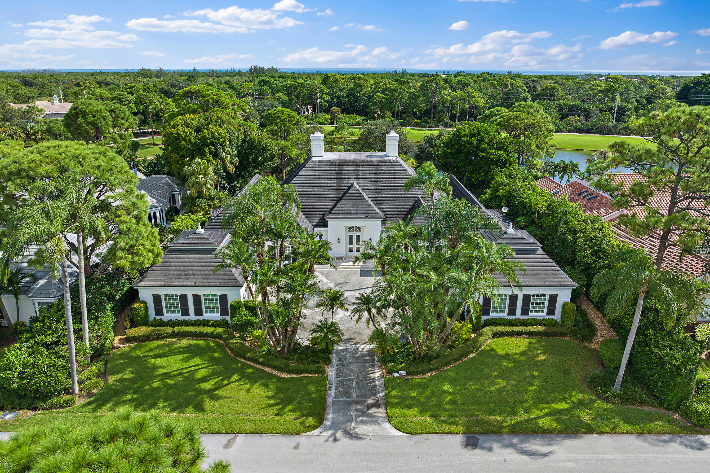 Welcome to the crown jewel of Loblolly Pines, the first home built in this prestigious community, where luxury and refined living meet. Situated across from the newly renovated clubhouse and driving range, this 5,700 sq ft residence offers elegance and comfort at every turn. Soaring ceilings and French doors in the grand entry provide stunning views through the home to the pool and beyond, seamlessly blending indoor and outdoor spaces. The home features 4 bedrooms, 5 baths, a grand library, expansive living and dining areas, a chef's kitchen with lake and golf course views, and a light-filled studio. Outdoors, an expansive patio overlooks the 10th and 11th holes. This extraordinary property is a masterpiece of luxury and privacy. Every detail has been meticulously crafted, beginning with the soaring 20-foot ceilings that elevate the beauty of the main living areas. Sunlight pours through the French doors in the grand front entry, offering a stunning line of sight straight through the home, out to the sparkling pool beyond, seamlessly blending indoor and outdoor living. The home offers 4 spacious bedrooms and 5 luxurious baths, beautifully complemented by a grand library, expansive living areas, and an elegant formal dining room.  The heart of the home is the chef's kitchen, a spacious haven with custom cabinetry and an oversized island, perfect for culinary adventures.  The large bay window frames breathtaking views of the tranquil lake and golf course, creating a serene backdrop for everyday living. Off the main living area, French doors lead to an expansive patio that runs the length of the home, providing a perfect setting for entertaining or quiet reflection.  From this vantage point, you'll enjoy panoramic views of both the sparkling pool and the rolling fairways, including the stunning 10th green. The home also boasts a light-filled studio and an airy loft with its own private patio, offering a peaceful retreat for moments of solitude.  Whether it's for creative pursuits or simple relaxation, this versatile space provides a personal sanctuary. Three elegant fireplaces, rich hardwood floors, and intricate crown moldings further enhance the timeless charm of this residence.  Outdoors, the pool area overlooks the 10th and 11th holes of the golf course, inviting you to bask in the serene beauty of the landscape. This extraordinary property is not just a home, it's a masterpiece, offering a rare blend of luxury, comfort, and privacy in one of the most sought-after communities.