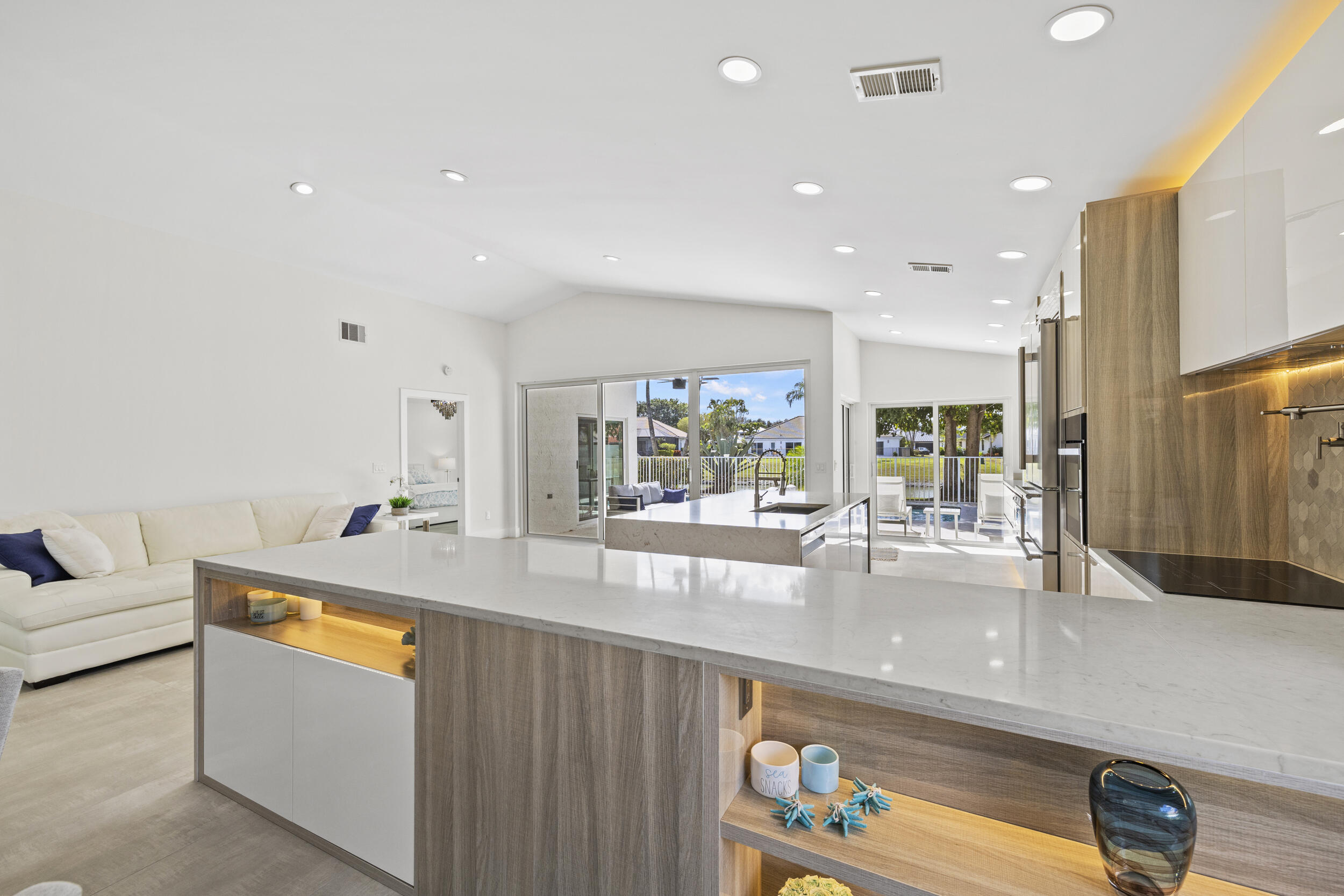 A true piece of paradise in Boca Woods Country Club. This fully renovated home features a light and bright open floor plan with thoughtful design throughout. The chef-inspired kitchen offers European cabinetry, quartz countertops, and high-end stainless steel appliances framed with beautiful lake and golf course views. The primary bedroom has a spa like bathroom and custom cabinets in the  walk-in closets. 2 secondary spacious ensuite bedrooms. Enjoy a unique private atrium with a custom waterfall and spa hot tub. Outdoors, relax on the extended marble deck with a saltwater pool and stunning lake and sunset views. Located at a pie shaped lot on one of the best cul-de-sacs in the community, offering the exceptional Boca Woods golf and country club lifestyle. Step inside and fall in love!