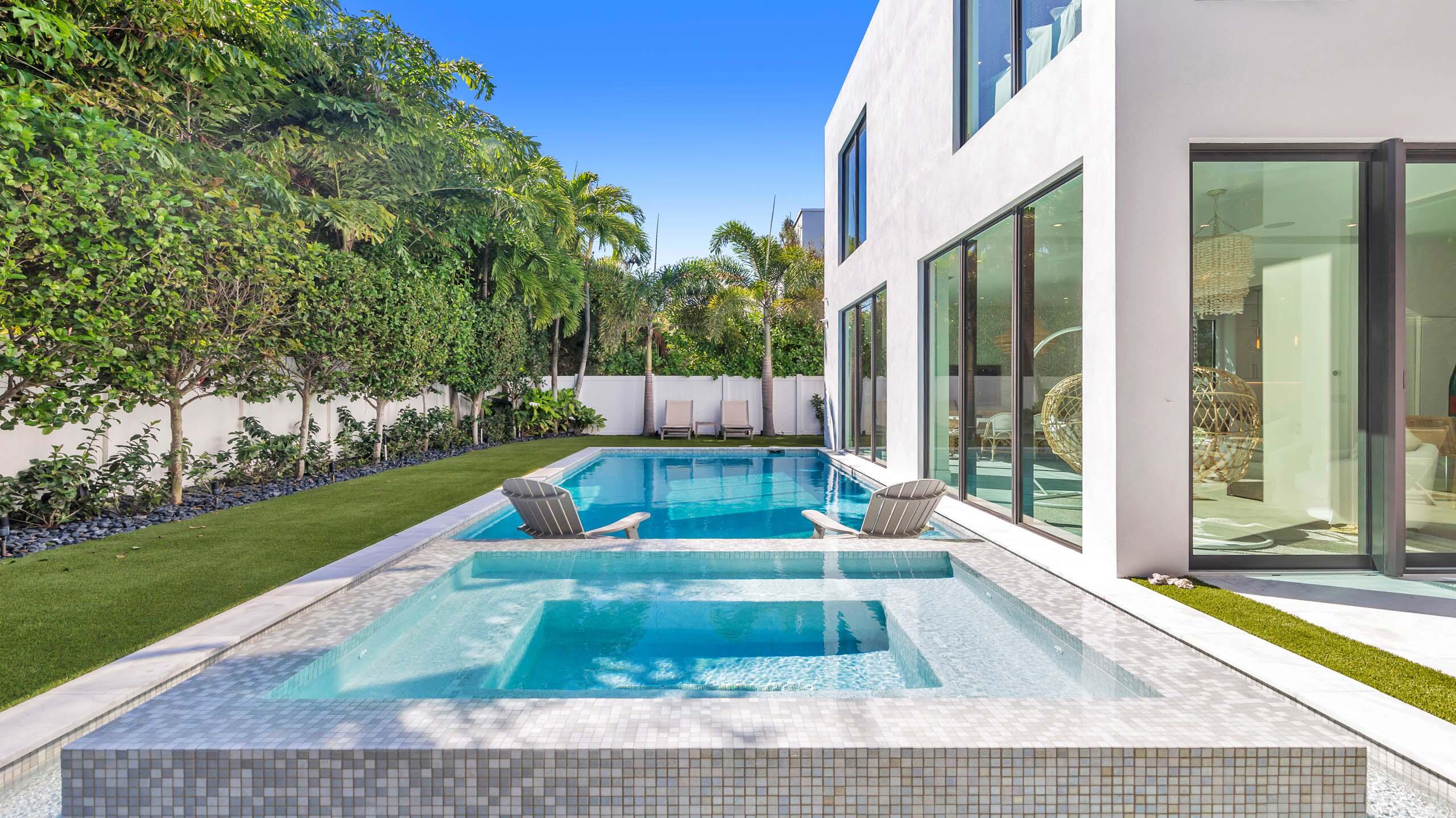 Built in 2021, this incredible contemporary residence is located in Boca Villas just one block from the famed Mizner Park and one mile to the beach. Features include volume ceilings; state-of-the-art AV system; designer touches throughout; and resort-like grounds to create an oasis for residents and guests alike. Boasting almost 6,500 total square feet, the five bedroom home offers spacious living areas; fabulous kitchen with snack bar seating; custom wine storage; and floor-to-ceiling windows and sliders that provide natural light and stunning views of the tranquil pool and grounds. The primary suite provides a private retreat with sitting room with morning bar; dual closets; spacious bathroom; and dedicated washer and dryer. FEATURES
" Boca Villas Residence built in 2021
" Located in East Boca Raton one block from Mizner Park and one mile from the beach
" 5 bedrooms / 5.1 baths
" 4,928 square feet under air / 6,479 total square feet
" Fabulous curb appeal with manicured landscape, decorative driveway, and path to front door
" Foyer entry opens to the spacious living areas with volume ceilings; floor to ceiling windows and sliders; and views of the pool and grounds
" Custom wine storage and fabulous bar with seating and fridge
" Sitting area off foyer with built-in shelves and cozy corner space overlooking the pool
" Modern kitchen with quartz countertops; Thermador appliances including gas range; island with second sink and snack bar seating; and lots of cupboards and storage space
" Dining Area flows effortlessly from the kitchen with views of the pool and grounds
" Primary suite with sitting area and morning bar; dual closets; spacious master bath with dual vanities; and dedicated washer and dryer
" 4 additional en suite guest bedrooms
" Covered patio and outdoor dining area that overlook pool and grounds for a resort-like experience thanks to professional grade audio system, landscaping, lighting, etc
" Inviting pool with sun shelf, spa, heater and chiller
" Private and fenced backyard with professional sound system; green space; and room for lounging and recreation
" Full home Sonos System; full IT network; fully integrated and networked AV system throughout the house; outdoor Sonos sound system; and fully monitored alarm system
" Full house generator 
" Full water filtration system
" Impact glass windows and doors
" Two car climate controlled garage with tile floor; cabinetry; slat walls; and lift
" Two laundry rooms
" Professional closets with lighting
" Professional landscape lighting and landscape irrigation system
" Three AC zones plus garage

This five bedroom residence has everything you need to enjoy South Florida Luxury Living. Come home to East Boca Raton.