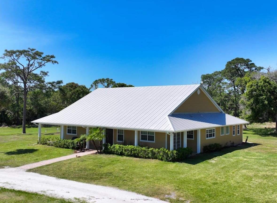 A true private retreat on 16.66 acres! This 4BR/4BA, 3,353-SF estate offers an open, light-filled floor plan with spacious living areas and gorgeous views of the property. Enjoy a stocked pond, multiple outbuildings for storage, equipment or hobbies, and plenty of room for horses or livestock. Peaceful wide-open spaces, mature trees, and exceptional privacy make this the perfect blend of country living and modern comfort - yet still conveniently close to town. 21st St SW between 43rd and 58th avenues will be paved. Don't miss out on this rare opportunity! New I-95 access also coming soon!  Current agriculture zoning with cattle.  Cattle are negotiable in order to maintain exemption.  Has front pond and separate pole barn for equipment storage.  Bring your horses and toys.