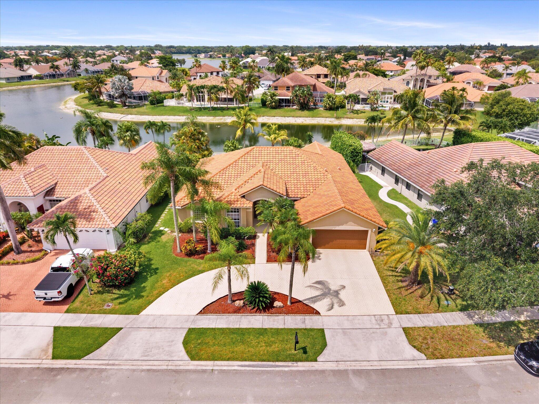 Move-In-Ready & Renovated 4-bed, 3-bath lakefront pool home located in the highly desirable Boca Winds community. Spacious single-story w/ open split floorplan features soaring ceilings, Luxury polished porcelain tile floors throughout & multiple living areas. The updated kitchen offers wood cabinetry, granite countertops, stainless steel appliances and reverse osmosis water filtration. The backyard is a dream boasting modern travertine marble pavers, spacious covered lanai, heated pool & spa with updated diamondbrite surface overlooking a scenic winding lake. Recent improvements include interior paint, impact windows (2024) along the pool side of the home, hurricane-rated front door, accordion shutters, newer roof (2019), electric car charger (2024), A/C (2020), and updated water heater. Boca Winds is one of West Boca Raton's most sought-after communities, known for its low HOA fees, resort-style amenities, and access to top-rated schools. Residents enjoy community pools, tennis courts, basketball courts, playgrounds, and scenic walking paths. Conveniently located near South County Regional Park featuring golf, water park, amphitheater, tennis, pickleball, dog park, nature center, and more. Just minutes from shopping, dining, major highways, and Boca Raton's beautiful beaches.