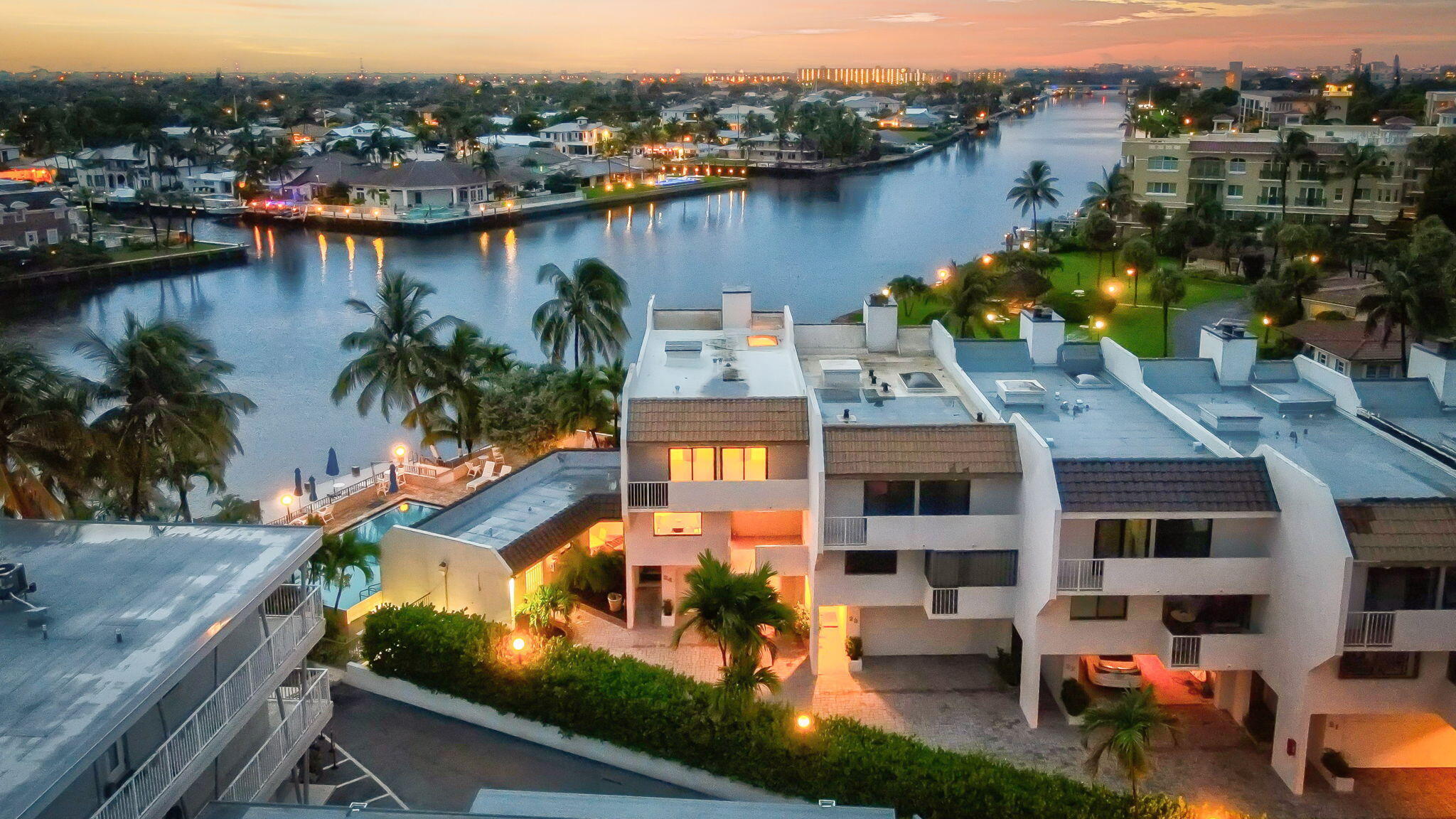 Exquisitely positioned on the coveted Hillsboro Mile, this fully furnished reimagined, coastal residence blends modern sophistication with effortless luxury. Boasting sweeping 180° Intracoastal views from an enviable corner lot, this designer townhome offers nearly 3,000 square feet of impeccably curated living space. Elegant architectural features include a bespoke glass-and-wood staircase, chef's-caliber designer kitchen, custom wine room, indulgent multi-person sauna, ambient electric fireplaces, and a rooftop skylight that invites natural light throughout. Every system is newly upgraded—impact-rated windows, dual-zone A/C, tankless water heaters, Private Elevator & a brand-new roof. Enjoy exceptional amenities including a waterfront pool, Community Dock, & deeded Beach Access. this rare gem seamlessly blends modern elegance with an unbeatable location between the Intracoastal and the Atlantic Ocean.