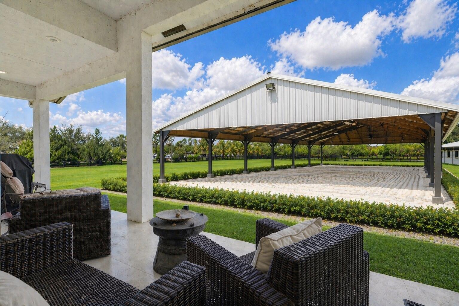 NEW CONSTRUCTION equestrian retreat on cleared, elevated land backing a bird sanctuary, with private access to 28 miles of horse trails. This 2023 modern home offers 4 bedrooms plus office/den, 3 full baths, hurricane-impact windows/doors, upgraded A/C, and whole-property reverse osmosis system. Equestrian amenities include a NEW 2024 European-style barn with twelve 12' x 12' stalls, ceiling and stall fans, 7 stalls with 48' runs and gated turnout access, 2 wash racks, tack/feed room, bathroom, and mudroom. A NEW CONSTRUCTION covered arena, 60' x 120', is being added, creating a complete private training setup. The property features six oversized 46' x 46' paddocks, additional 12' x 46' gated paddocks, connected turnout options, two driveways, and RV hookup. Located in a gated equestrian neighborhood with White Fences Showgrounds inside the community, just off Southern Blvd near WEF, IDA, Polo, and Wellington's A-rated schools.