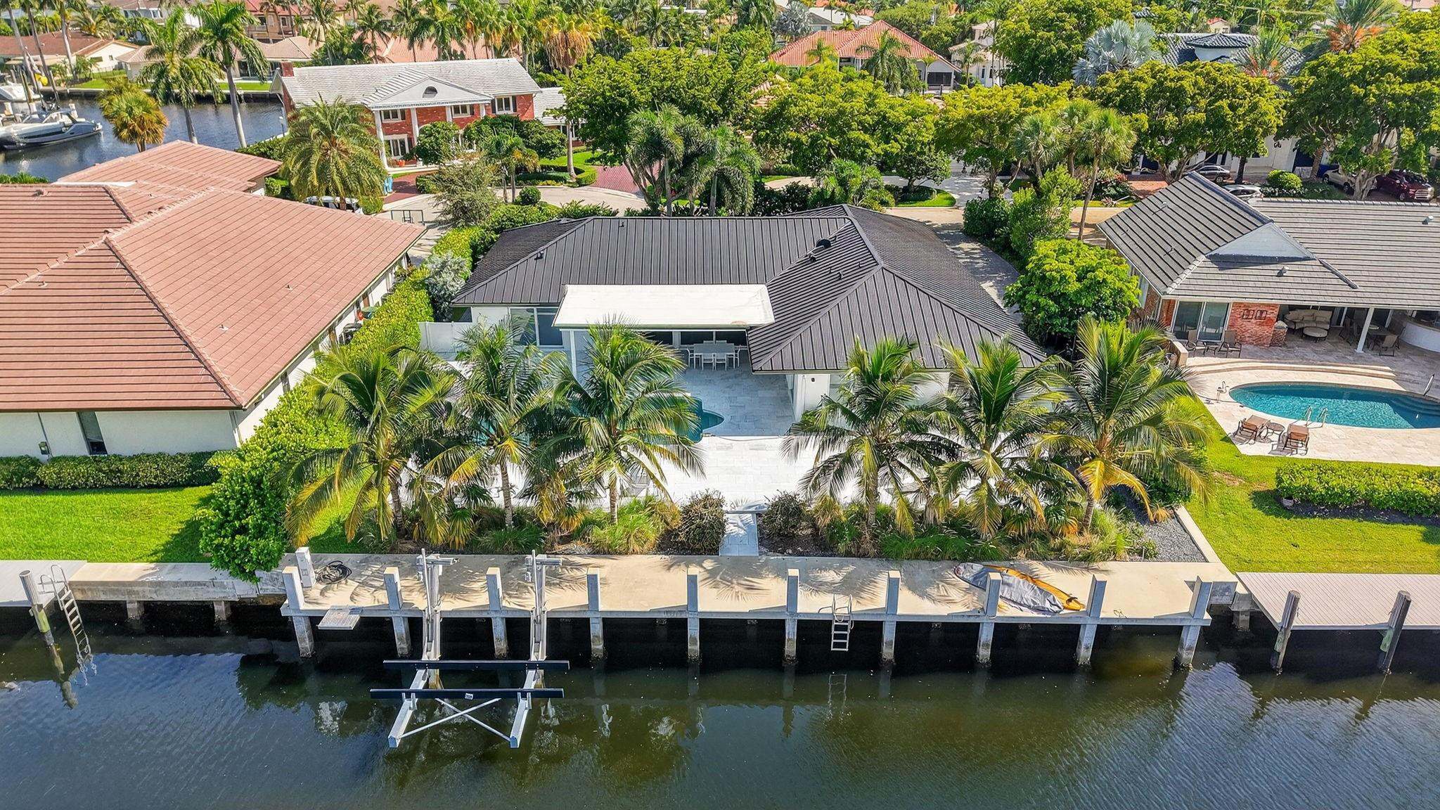 Located in Fort Lauderdale's premier 24/7 armed security guard-gated deepwater community. Move-in ready & furnished for quick closing. Custom island-inspired single level residence. 2022 total renovation shows as NEW: metal roof, plumbing to street, all new electrical, air conditioners, tankless water heater & generator. Latest open concept living, great room, Chef's kitchen, porcelain tile floors, new impact glass & interior doors. Private Primary Suite, dual closets, new modern spa style bath, enclosed water closet, soaking tub & floating vanities. Split floorplan: 2 secondary bedroom suites, office (4th bed), cabana bath, air-conditioned garage. Most rooms access pool & wide-open radius turning basin views, 95ft protected dockage. Perfectly located for Pine Crest & other A rated schools Bay Colony features full time (24/7) armed security with only one guard house and access point.  There are only 108 residences in Bay Colony as of this listing.2022 Custom Renovation (in addition to the above) includes:-Interior:* Large format porcelain tiles matching throughout the residence.* Mud-room/utility room with double LG washer and dryer systems and refrigerator, plus folding area and ample storage closets, desk area.* High-end plumbing features throughout include Porcelanosa and Toto* New interior doors & baseboards* Entirely new electrical service and custom lighting throughout the residence.* All new bathrooms with floating vanities and LED Mirrors.* Primary Suite: Separate custom closets, large spa style bathroom with enclosed water-closet, large shower and soaking tub. Window to exterior for natural light. Floating Italian style vanities with LED Mirrors & make-up area. Sliders to the pool area.* Entirely separate wing for the two secondary suites (both with new custom bathrooms) and home office (potential 4th bedroom). New cabana bathroom with exterior door to pool area.* Side access oversized air-conditioned garage with epoxy floors and large windows provide natural light. Currently doubles as gym.* Water softener* Tankless water heaterExterior:* Two Carrier Air Conditioners - 5 and 2 ton.* Circular driveway includes side access garage with parking for at least 6 cars on the side plus the circular driveway.  All new pavers in the front and side pathways. New double entry front doors.* Fenced and gated rear backyard.* Fully renovated pool with marble pool decking and large covered terrace provides for outside dining and lounging.* Marble decking surrounds the entire pool area with large sunning area and separate area for firepit and grilling.* New docking with lighting and electrical service (boat lift excluded)* Professional landscaping throughout the entire property.24 KW Generator* New sea wall cap and dock