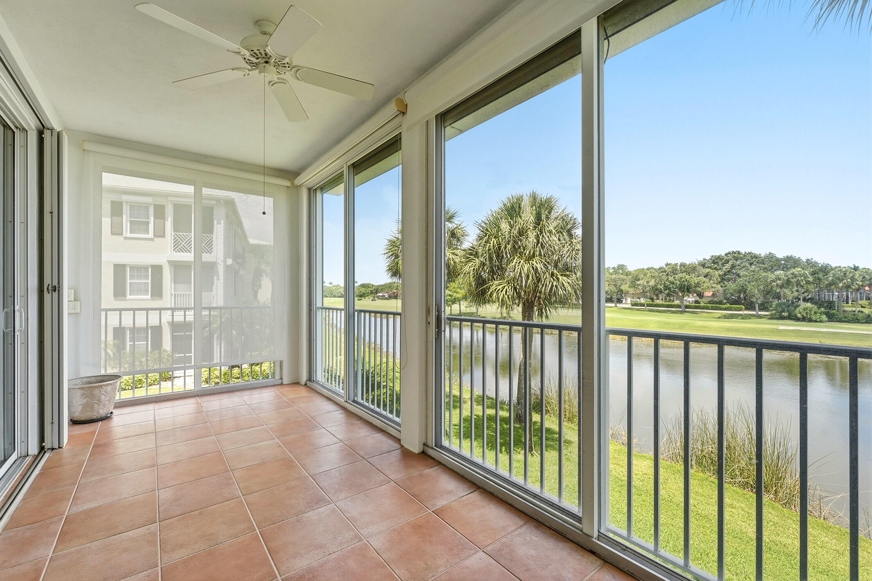 Experience spacious luxury in the largest corner unit in Camden House, offering 2,147 square feet of light-filled living space. This beautifully maintained split-floorplan residence showcases sweeping lake views overlooking the 2nd hole of the River Course.  Designed for comfort and year-round enjoyment, the enclosed Florida Room is fully air-conditioned and can be separated from the main living area with closing doors — creating the perfect bonus space for relaxing, entertaining, or working from home.  Additional highlights include plantation shutters, easy-to-use hurricane protection, a 2022 A/C system, and a 2021 water heater, providing peace of mind and effortless living.  Located within Oak Harbor, a private gated country club community in Vero Beach for active adults 55+, residents e