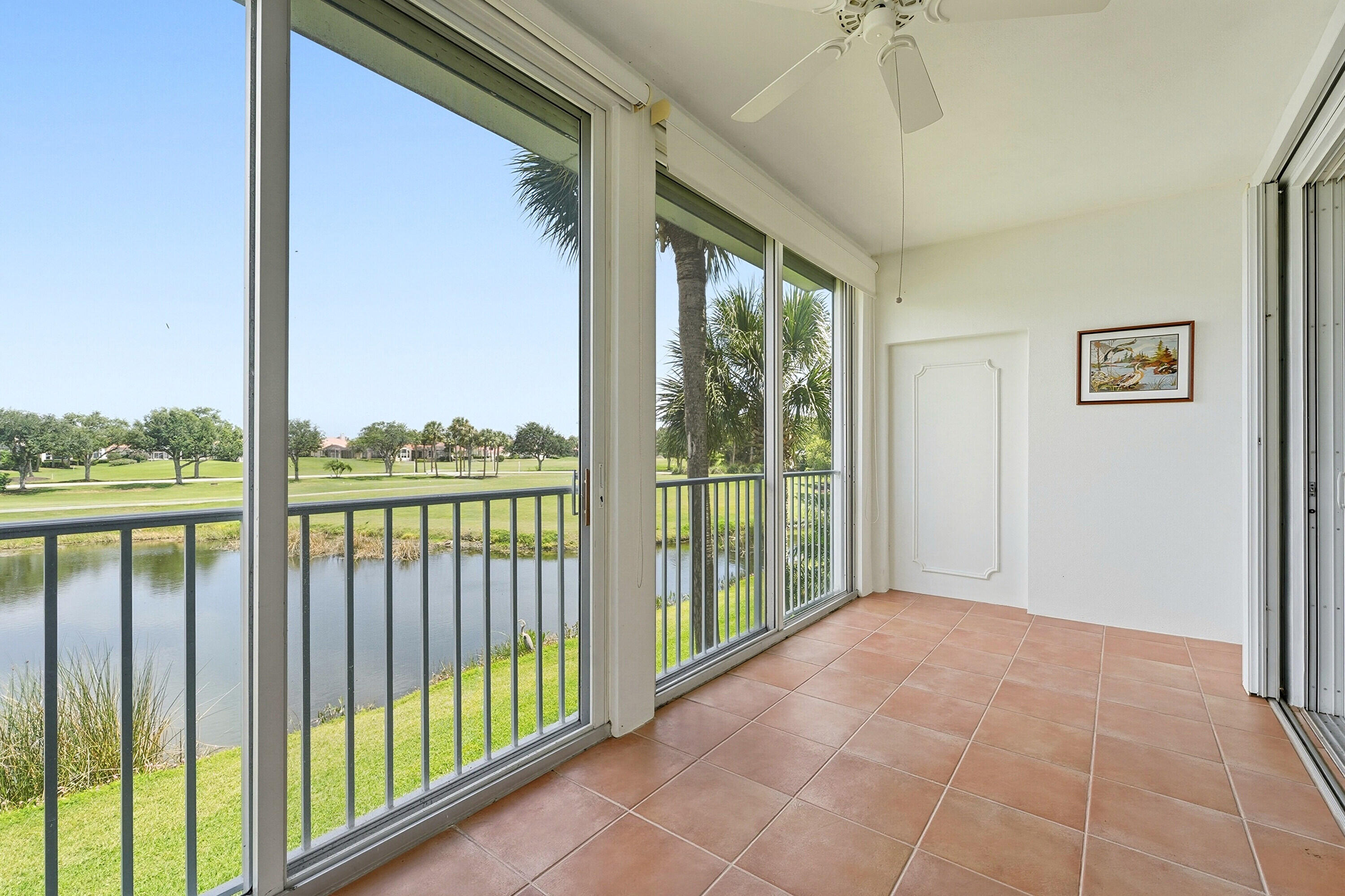 Experience spacious luxury in the largest corner unit in Camden House, offering 2,147 square feet of light-filled living space. This beautifully maintained split-floorplan residence showcases sweeping lake views overlooking the 2nd hole of the River Course.  Designed for comfort and year-round enjoyment, the enclosed Florida Room is fully air-conditioned and can be separated from the main living area with closing doors — creating the perfect bonus space for relaxing, entertaining, or working from home.  Additional highlights include plantation shutters, easy-to-use hurricane protection, a 2022 A/C system, and a 2021 water heater, providing peace of mind and effortless living.  Located within Oak Harbor, a private gated country club community in Vero Beach for active adults 55+, residents e