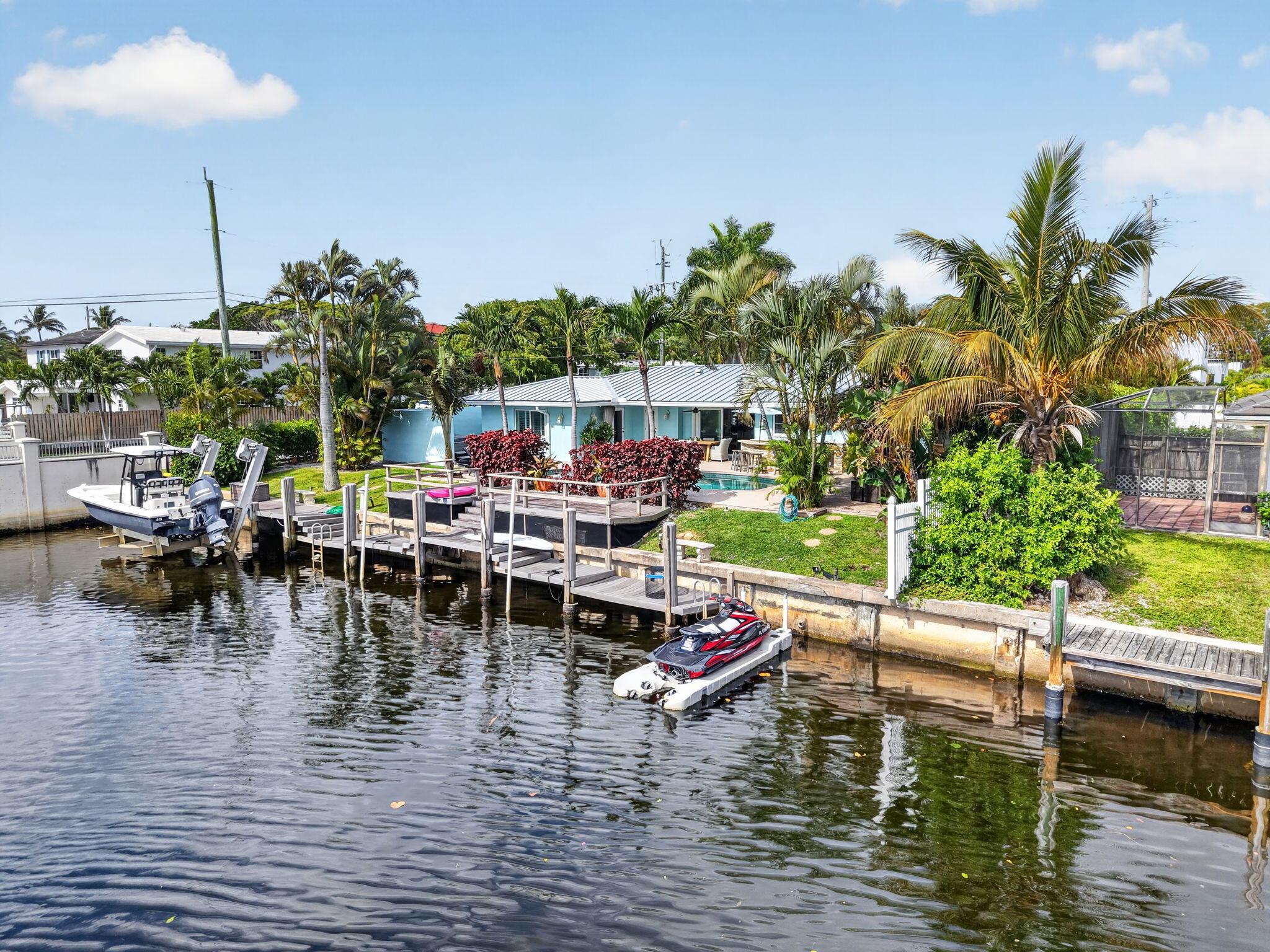 Welcome Home to this boater's paradise. Live the Florida life in this gorgeous 3 bedroom 2 bath pool home on corner lot with 100 ft of water frontage in 1 of Boca Raton's best & most convenient waterfront communities. Situated on a navigable canal with no fixed bridges & just minutes to ocean access, this open concept home has space to entertain with granite countertops, white cabinets & stainless steel appliances. High ceilings, plantation shutters, & marble & wood floors complete the look. Enjoy the water view from every area of the open layout. Impact rated glass doors & windows & a 2024 roof ensure comfort, style & ease. It feels like a resort with a tiki hut, summer kitchen & hot tub. The covered patio overlooks the large dock, floating dock & boat lift on the extra wide canal. Enjoy!