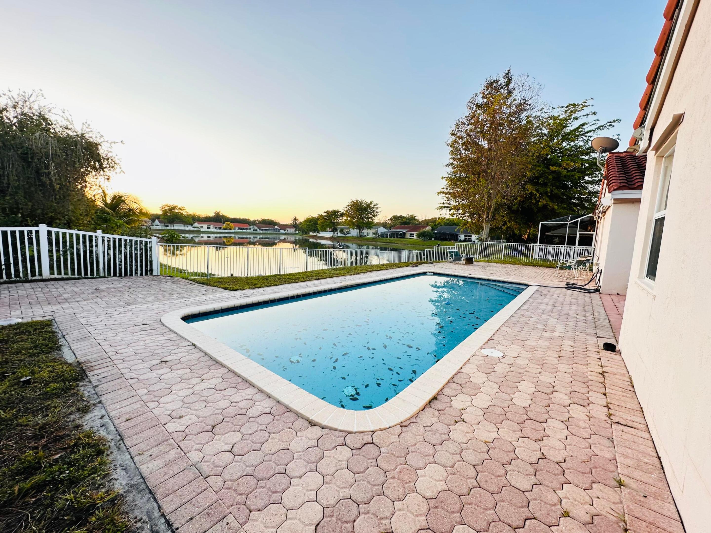 This spacious 3 bedroom, 2 bathroom home sits on a large lot with a wide view of a serene lake and a sparkling pool.  The split plan layout allows for privacy and easy flow.  With a view of the lake and pool from the primary bedroom, living room and family room. Natural light pours into the house, from the three sets of sliding doors. The circular drive way and 2 car garage offer space for all your guests. The home is located in one of Miramar's most sought after neighborhhods with mature trees creating a canopy over the quiet and serene neighborhhood.  Excellent schools, shopping, dining and major highways are near by making this neighborhood even more appealing.  The HOA is a low $77 per month.  Schedule a tour today! The sellers are very motivated to sell.