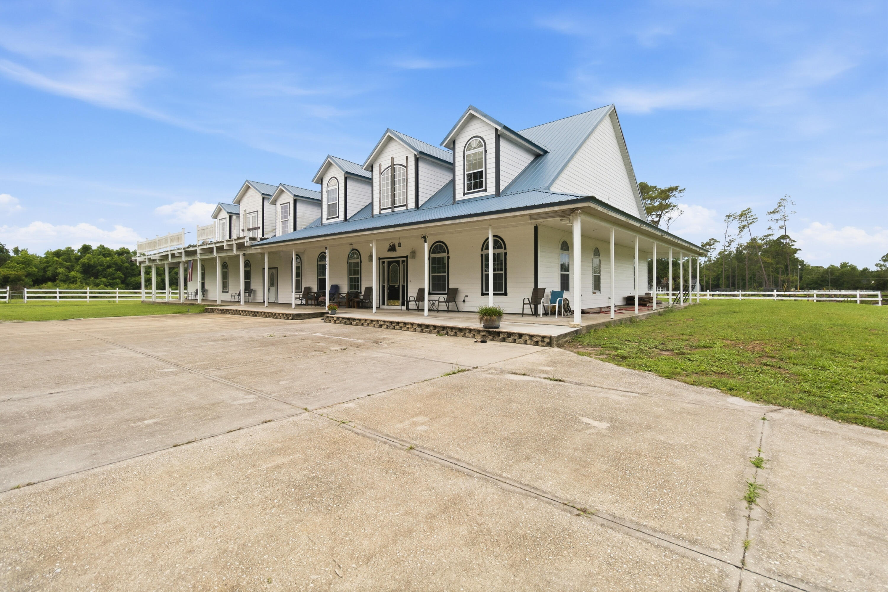 Virtually staged. Designed, permitted, and engineered beyond Florida building code standards, this exceptional 10.5-acre equestrian estate offers nearly 9,000 SF under roof and a rare blend of craftsmanship, versatility, and long-term value. The property features a 6BR/4BA main residence, private apartment, studio suite, and a 4-car garage/workshop with expansive covered porches. Built for durability and efficiency with commercial-grade construction, metal roof system, buried utilities, private well, and whole-house water treatment, the estate also offers true self-sufficiency potential. An income-producing 11-stall permitted barn with direct access to Seminole State Forest trails completes this unique agricultural offering with no HOA, Flood Zone X designation, and unmatched privacy.  This one-of-a-kind equestrian estate was owner-designed, permitted, and engineered to exceed Florida building code standards, offering a rare combination of structural integrity, versatility, and long-term land value across 10.5 protected acres.  Encompassing nearly 9,000 square feet under roof, the property includes a thoughtfully designed 6BR/4BA main residence, a private upstairs apartment, and a separate studio suite, providing exceptional flexibility for multigenerational living, guest accommodations, or rental income. A 4-car garage and workshop, extensive covered porches, and additional unfinished space further enhance the property's adaptability for future customization.  Built with durability and efficiency in mind, the home features commercial-grade construction materials, enhanced insulation systems, a high-performance metal roof assembly, buried utilities, private well, and a whole-house water treatment system, creating a residence that is both resilient and self-sufficient in design.  The property also includes a fully permitted 11-stall equestrian barn with an established boarding history and direct trail access to Seminole State Forest and Rock Springs Run Preserve, eliminating the need for trailering and offering immediate access to miles of riding trails.  Agricultural zoning, Flood Zone X designation, and absence of HOA restrictions provide rare freedom for use and expansion, while the surrounding Wekiva River Protection Zone ensures long-term privacy and protection from future overdevelopment.  With income-producing potential, generational land value, and unmatched natural surroundings, this estate offers a truly rare opportunity for equestrian, investment, or self-sustained living.