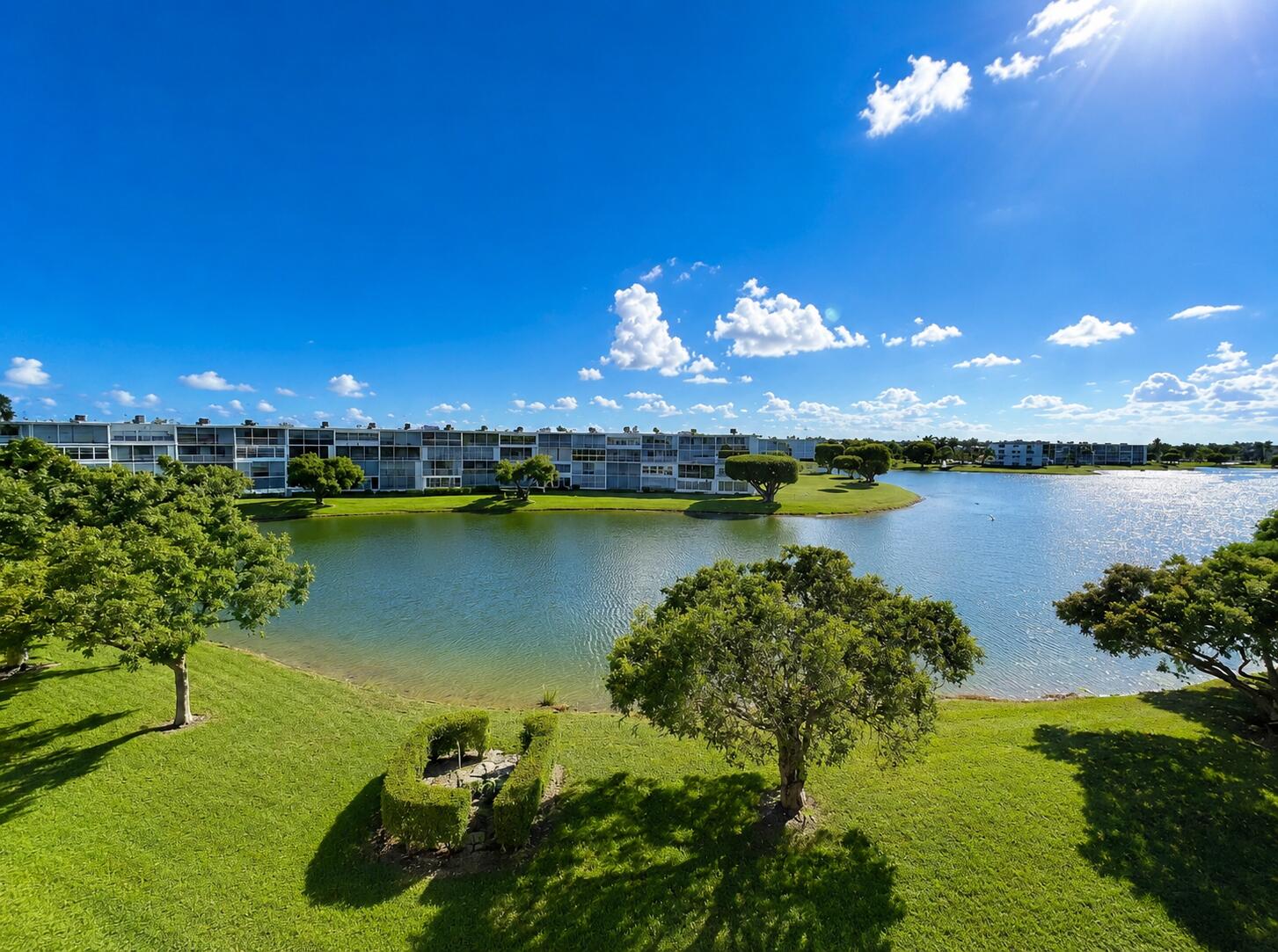 Wake up to peaceful lake views and enjoy the carefree South Florida lifestyle in this bright and freshly painted 2-bedroom, 2-bath residence located on the 4th floor of Boca Raton's renowned Century Village. Natural light fills the spacious interior, where the open living and dining areas create an inviting setting for both everyday living and entertaining. The kitchen offers granite countertops, stainless steel appliances, abundant cabinetry, and generous prep space. The enclosed balcony features sliding windows and screens, creating the perfect year-round retreat to relax, unwind, and take in the tranquil water and garden views. The primary suite provides ample closet space and a private bath, while the guest bedroom comfortably accommodates visitors, hobbies, or a home office. Association fees include cable TV, internet, water, sewer, insurance, maintenance of common areas and grounds, and access to an impressive array of resort-style amenities. Century Village offers an unmatched active-adult lifestyle with multiple pools, a state-of-the-art fitness center, tennis and pickleball courts, billiards, card rooms, bingo, classes, clubs, movies, live entertainment, organized trips, and courtesy transportation throughout the community and beyond. Whether you're looking for a full-time residence or seasonal getaway, this lakefront retreat offers exceptional value, comfort, and an amenity-rich lifestyle in the heart of Boca Raton.