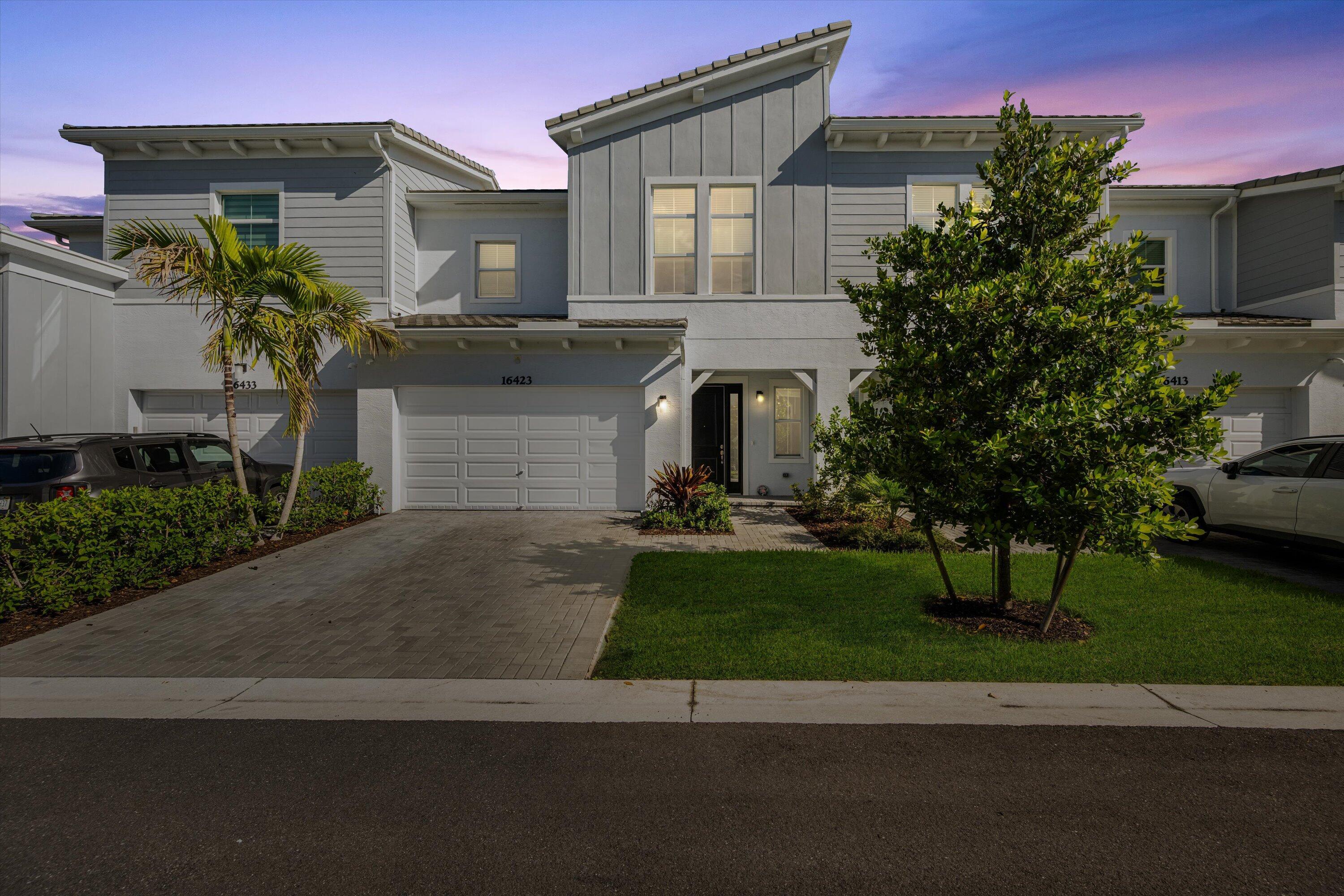 Welcome to the highly sought-after Biscayne model in The Crossings community in Westlake, FL! This spacious three-bedroom, two-and-a-half bathroom, two-story townhouse offers modern style and an inviting open layout. Step through the striking black front door into a bright first floor with tile flooring throughout and an expansive living room, a separate dining area, and abundant natural light. The chef's kitchen showcases rich brown shaker cabinets, granite countertops, stainless steel Whirlpool appliances, and a large island with ample storage—perfect for entertaining or family gatherings. A convenient powder bath is also located downstairs. Upstairs, laminate flooring continues through the hallway, stairs, and master suite, where elegant double doors lead into a generous bedroom with tray ceiling detail. The master bath features a tub and shower combination, dual sinks set opposite each other, plentiful storage, and matching brown cabinets with granite countertops. Two additional bedrooms offer comfortable space and cozy carpet, sharing a full bath with a tub and the same high-end finishes. A dedicated laundry room with Whirlpool appliances and coordinating cabinetry completes the second floor.  Outside, enjoy a fenced patio with extended pavers and a covered lanai, perfect for relaxing or entertaining. A two-car garage adds convenience to this beautifully maintained home. Experience the best of Westlake living with Cresswind's exceptional amenities and vibrant neighborhood atmosphere!