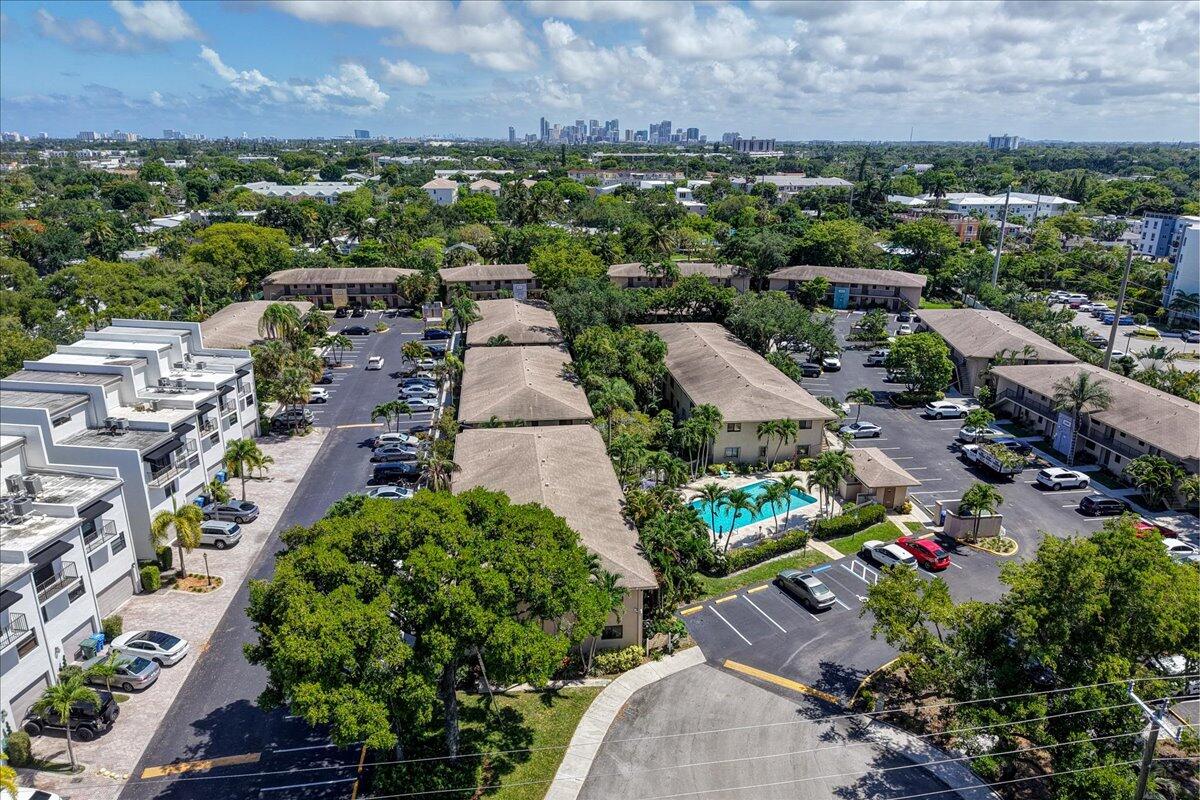 Beautifully updated ground floor 2BR/2BA corner unit situated moments from the vibrant dining and nightlife of Wilton Drive. This unit is perfect as a permanent home, seasonal getaway, or savvy investment. Living room opens to lushly back patio, positioned just steps away from the sparkling community pool for seamless indoor-outdoor living. It feels like having a resort in your own backyard! Modern kitchen features rich wood cabinetry, granite countertops, stainless steel appliances, and a unique modern backsplash with under-cabinet accent lighting. Fully equipped with all impact windows and doors for peace of mind and efficiency. Convenient in-unit laundry with full size washer and dryer. Low overhead with just $360/mo maintenance. Pet friendly!