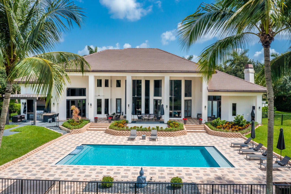 This magnificent 1.15-acre lakefront estate in Windmill Ranch Estates offers a lifestyle defined by soaring 22' ceilings, stunning living spaces, and gourmet kitchen. Floor plan features, main-level primary suite, office/flex space, guest room, second floor has 3 bedrooms and studio. Oversized covered patio with a summer kitchen, outdoor fireplace overlooks the oversized pool and lake. Updates include a 2018 roof, 2019; HVAC (4), and new appliances. Priced  incorporating no impact. Truly an amazing home