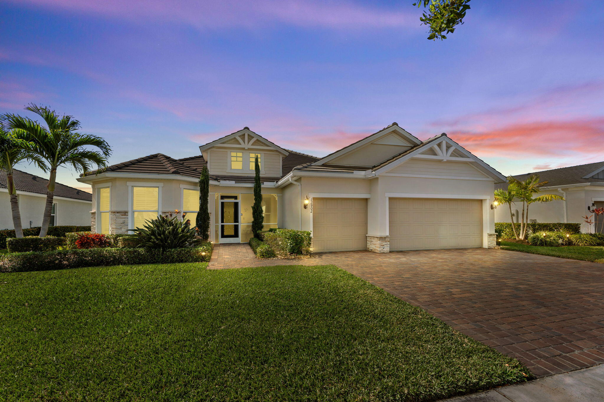 Discover this Magnificent Waterfront Pool Home in Del Webb at Tradition. Experience Elevated Florida Living in this exceptional 2019 CBS-Built Luxury Residence, perfectly situated on a premium- Waterfront Lot. Designed for both Elegance and Functionality, this Home has it ALL! Offering 3 Bedrooms, plus a private office/den, 3 full Bathrooms (including en-suite), and a 3-Car Garage. From the moment you arrive, the Paver driveway and entry set the tone for the quality and attention to detail found throughout. No expense was spared! Step inside this open and spacious layout, enhanced by Wood-Plank Tile flooring, all 8-foot doors, and custom Wainscoting in the main Living Area and Primary Suite, creating a refined yet inviting atmosphere. The Chef's Kitchen is a true showpiece, featuring 42-inch custom Cabinetry with organizers, Quartz Countertops, S/S KitchenAid Appliances on Natural Gas, a custom Hood vent, expansive Island with Bar seating, built-in Pantry, and a custom Wet Bar, perfect for entertaining. A separate Formal Dining Area provides an elegant setting for gatherings. Seamless indoor-outdoor living is achieved through a Zero Corner- sliding glass door that opens to your own private oasis, featuring a screened-in pool, and spa with a Travertine deck, overlooking tranquil Lake Views and breathtaking sunsets. The Spa and Pool features are app-controlled, including lighting and settings, Electric Roll Down shades and a New Pool heater and Pump for peace of mind. The Primary Suite offers a luxurious retreat with a custom built-in walk-in closet, Dual Vanities, and a walk-in Shower. Additional highlights include surround sound throughout the home, plantation shutters, a whole-home Generac Generator, epoxy-coated garage floors with custom cabinet storage, and a well-appointed laundry room. Del Webb at Tradition offers a resort-style, 55+ gated lifestyle with a private clubhouse, state-of-the-art fitness center, pickleball, tennis, bocce, swimming pools, and a full calendar of clubs and social activities. Located within Tradition, Residents enjoy access to a vibrant town center with shopping, dining, entertainment, medical facilities, walking trails, and year-round community events, all just minutes from home. This Waterfront Luxury Home delivers timeless design, modern convenience, and an unmatched lifestyle. Schedule your private showing today.