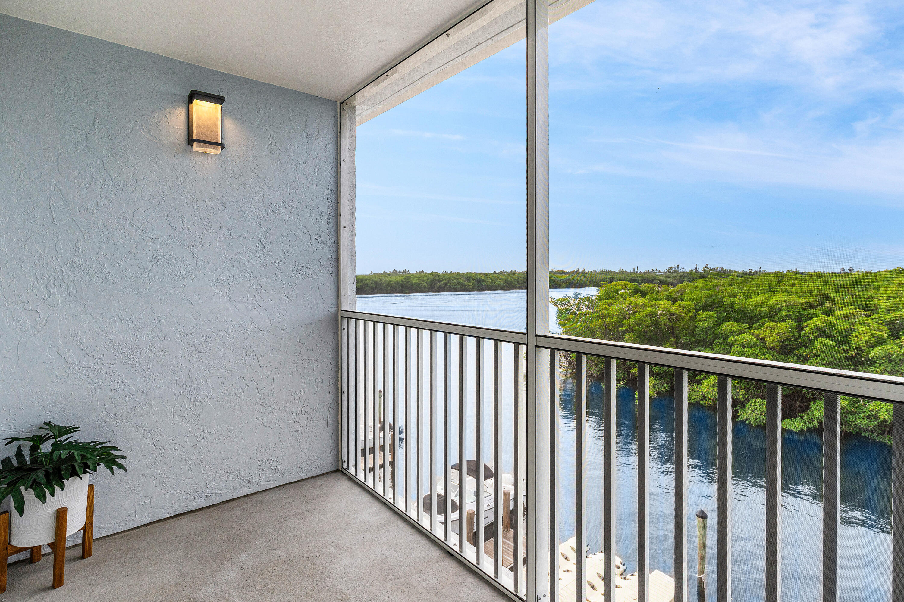 INTRACOASTAL VIEWS FULLY RENOVATED! Experience waterfront living at its finest in this beautifully renovated penthouse on the Intracoastal. Filled with natural light throughout, this bright and airy one bedroom, one bath residence features a sleek walk-in shower and a spacious bedroom with plantation shutters framing exceptional water views, plus a generous walk-in closet with custom built-ins. A coastal-inspired custom bookshelf in the hallway leads to the primary bedroom, adding both charm and functionality. The thoughtfully designed kitchen showcases quartz countertops, a wall oven, open-concept shelving, and abundant cabinetry with drawer storage, all seamlessly flowing into the inviting eat-in dining area. The open living room captures sweeping water views watch boats glide in or enjoy the community kayaks launching from the dock. Step onto the screened-in balcony overlooking the tranquil nature preserve, the perfect setting for morning coffee or evening sunsets. Every detail has been elevated to combine modern elegance, coastal character, and the tranquility of waterfront living. This penthouse is ideal for those seeking a low-maintenance lifestyle, unmatched views, and direct access to nature.