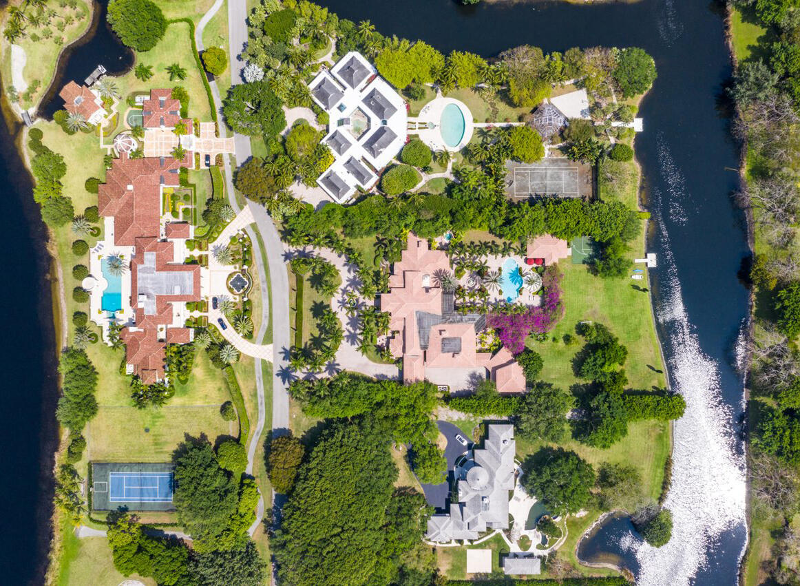 Elegance abounds at 6025 Le Lac Road in Boca Raton's ultra-private gated community of Le Lac, once ranked by Forbes in the top 10 gated U.S. neighborhoods. This magnificent 2.5 acre waterfront estate is an architectural masterpiece showcasing a grand 100' gallery, with soaring groin vaulted ceiling, lined by imported carved limestone columns, authentic Venetian plaster and classic polished marble flooring.  Perfect for showcasing an art collection and entertaining. This classic estate home has lavish finishes, attention to detail and outstanding craftsmanship. Features include a movie theater, gym with sauna, wine cellar, multiple wet bars, epic pool lined with fountains backed by spectacular slides, cabana with outdoor kitchen, batting/golf cage, and 5 car garage with limousine stall