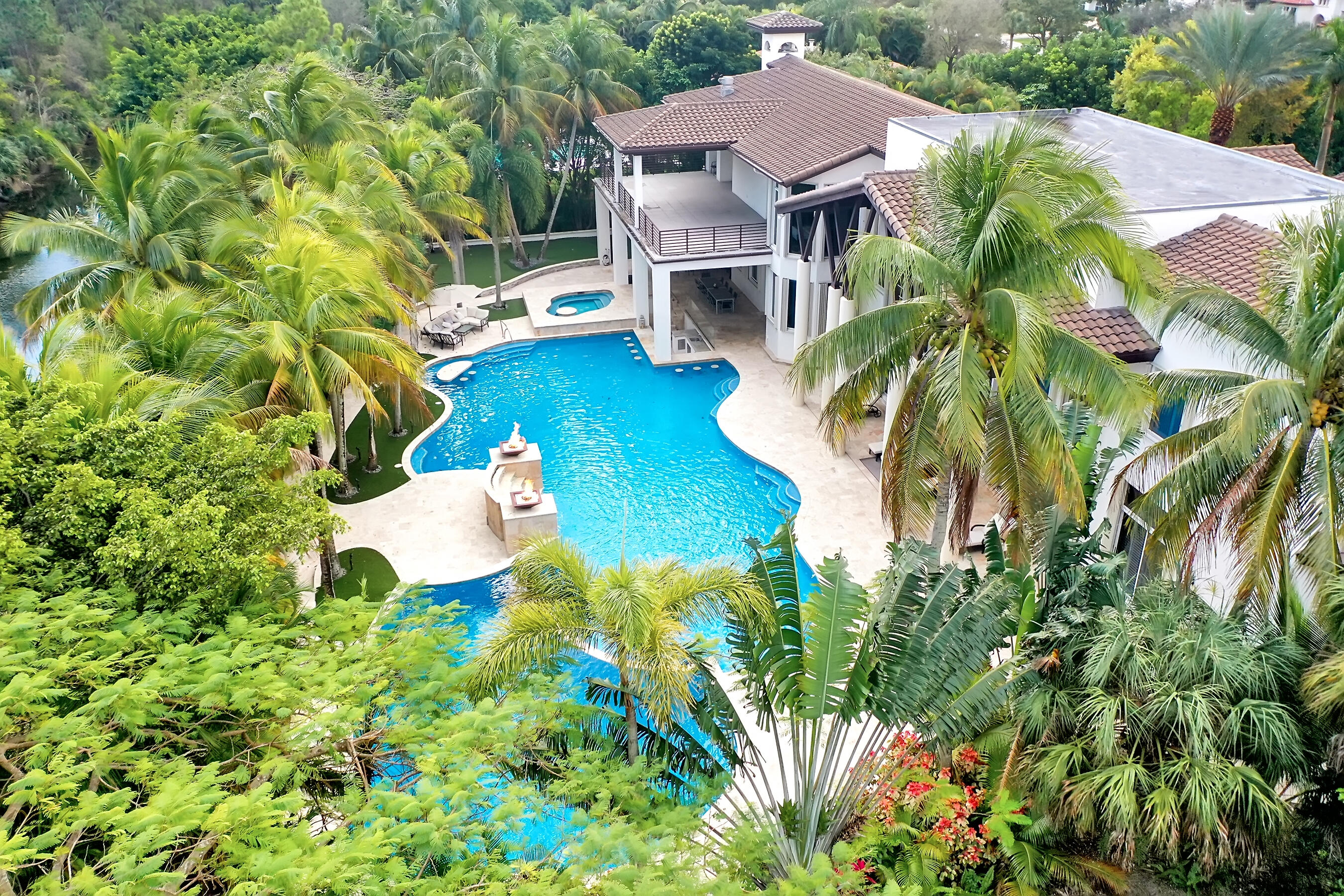 Magnificent mixture of mid-century modern and contemporary architectural masterpiece, 11,794 total square feet on 2.2 acres of private gated compound. Walk in the foyer to dramatic 30 foot ceilings and a 600 gallon jellyfish tank. Hi-end stainless steel appliances, gourmet kitchen, granite countertops, hardwood & marble floors throughout the living area! Large den, office & recreation room. Very nice in-law quarters completely separate from the main house with a full kitchen. The main attraction is the 140,000 gallon swimming pool, jacuzzi with waterfalls with a fire feature, & a swim-up bar. Large windows everywhere, sun filled in every room. Private patios w/ views of pool, land, basketball court, and much more. If you love to entertain this is the home for it, it is your own resort! 441 TO HOLMBERG HEAD WEST TO NW 62 TER - END OF THE STREET ON THE RIGHT.