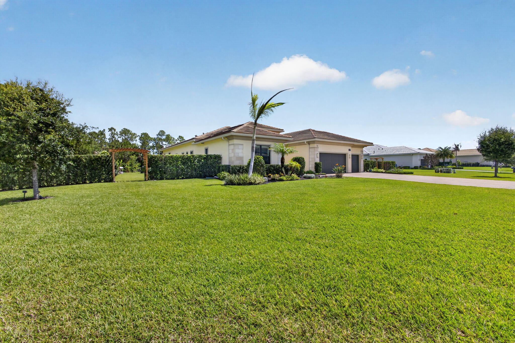 Nestled on a private 0.6-acre cul-de-sac lot  inside a nature preserve, this exceptional Palm City residence offers the perfect blend of luxury, privacy, and peace of mind. A lush Podocarpus hedge and charming cedar pagoda entrances create a stunning first impression, while the expansive screened lanai overlooks the preserve, colorful gardens, and fruit trees. The oversized 3-car garage offers overhead storage racks and is complemented by an extended driveway. Built for Florida living, the home is equipped with impact-resistant hurricane windows, doors, and garage doors, a 24kW whole-house Generac generator with WiFi monitoring, a 5-ton heat pump with Ecobee WiFi thermostat, and a built-in security system plus Ring camera system. Additional highlights include granite countertops  Designed for both comfortable living and entertaining, the home features a spacious floor plan with a living room, family room, den, formal dining room, breakfast nook, and laundry room. Soaring 11+ foot ceilings, elegant crown molding, plantation shutters, tile flooring throughout, and crystal chandeliers in the foyer, living room. The dining room add timeless sophistication. The thoughtfully designed layout includes two guest bedrooms, each with its own walk-in closet and private full bath, plus a luxurious owner's suite featuring dual walk-in closets, a spa-like bath with soaking tub, and an oversized dual-head shower. An additional half bath serves guests. A rare opportunity to own a private estate-sized property in one of Palm City's most desirable settings. 3 Bedrooms | 3.5 Baths | Den | 3-Car Garage | 0.6 Acres | Preserve​​‌​​​​‌​‌​​​‌‌​​​‌‌‌​​‌​​‌‌​​​​ Views