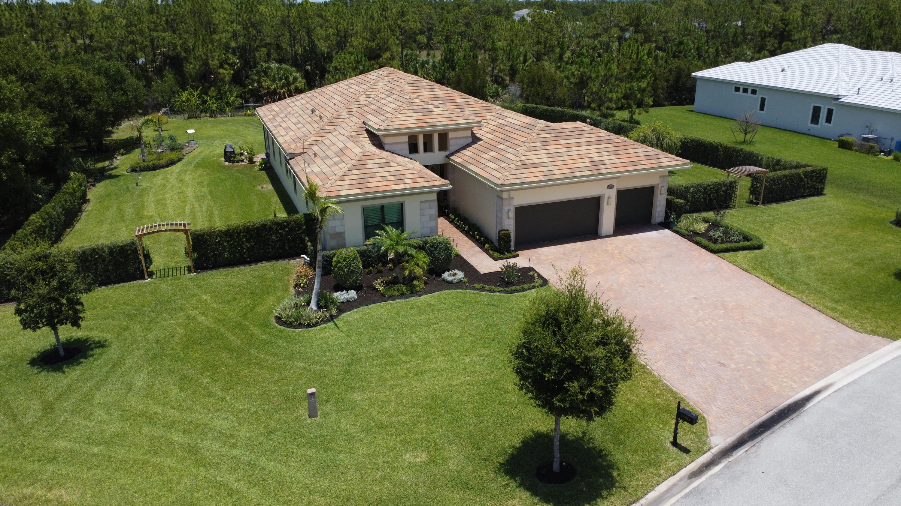 Nestled on a private 0.6-acre cul-de-sac lot  inside a nature preserve, this exceptional Palm City residence offers the perfect blend of luxury, privacy, and peace of mind. A lush Podocarpus hedge and charming cedar pagoda entrances create a stunning first impression, while the expansive screened lanai overlooks the preserve, colorful gardens, and fruit trees. The oversized 3-car garage offers overhead storage racks and is complemented by an extended driveway. Built for Florida living, the home is equipped with impact-resistant hurricane windows, doors, and garage doors, a 24kW whole-house Generac generator with WiFi monitoring, a 5-ton heat pump with Ecobee WiFi thermostat, and a built-in security system plus Ring camera system. Additional highlights include granite countertops  Designed for both comfortable living and entertaining, the home features a spacious floor plan with a living room, family room, den, formal dining room, breakfast nook, and laundry room. Soaring 11+ foot ceilings, elegant crown molding, plantation shutters, tile flooring throughout, and crystal chandeliers in the foyer, living room. The dining room add timeless sophistication. The thoughtfully designed layout includes two guest bedrooms, each with its own walk-in closet and private full bath, plus a luxurious owner's suite featuring dual walk-in closets, a spa-like bath with soaking tub, and an oversized dual-head shower. An additional half bath serves guests. A rare opportunity to own a private estate-sized property in one of Palm City's most desirable settings. 3 Bedrooms | 3.5 Baths | Den | 3-Car Garage | 0.6 Acres | Preserve​​‌​​​​‌​‌​​​‌‌​​​‌‌‌​​‌​​‌‌​​​​ Views