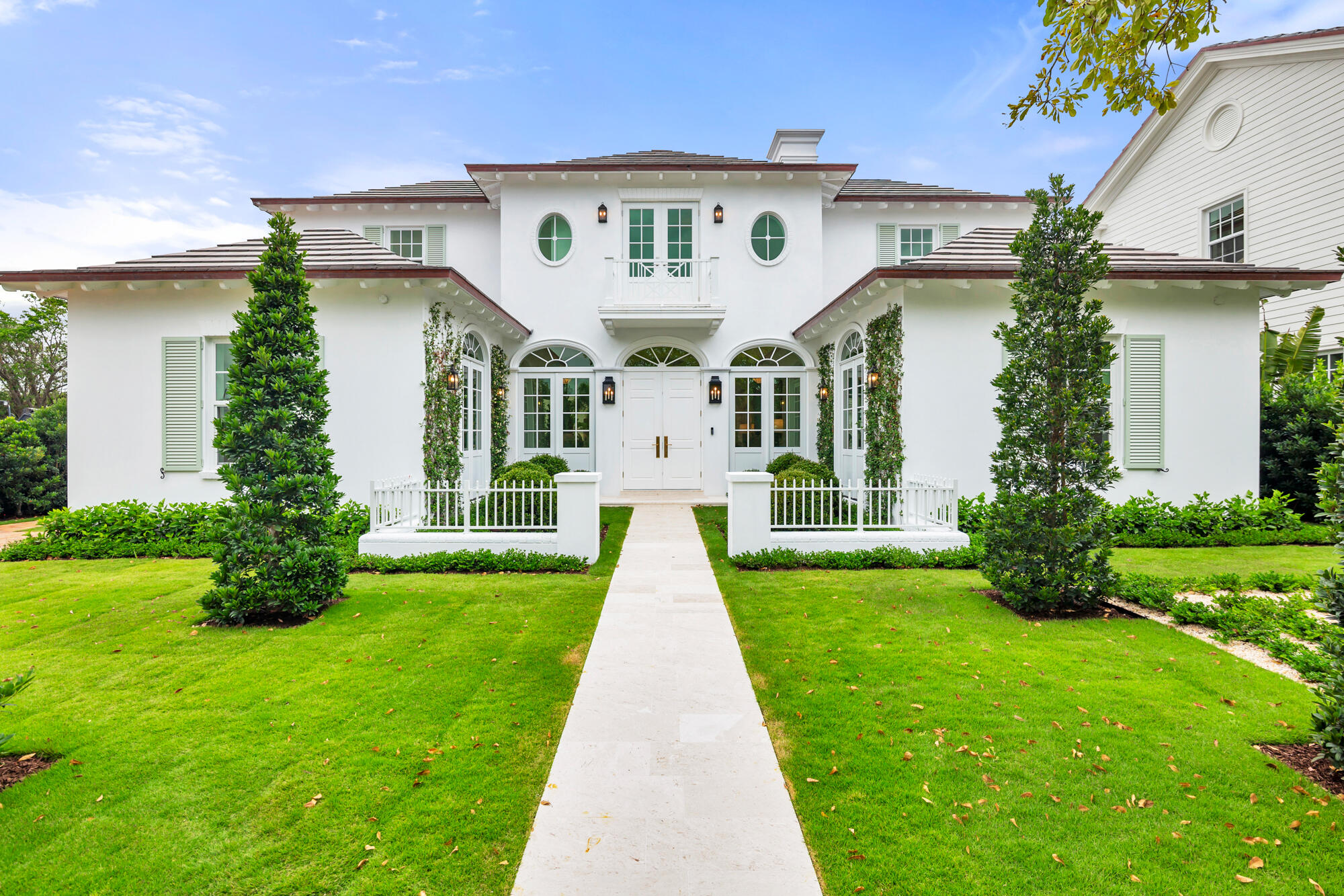 Situated in the coveted SoSo neighborhood, this newly constructed Anglo-Caribbean residence by Smith Kellogg Architecture offers 4,926 total square feet with 3 bedrooms, 3.5 bathrooms, and a private 1 bedroom, 1 bathroom guesthouse. A beautifully manicured entry courtyard creates a welcoming first impression, leading into interiors finished with white oak wood floors throughout. The main level is thoughtfully designed with a private office, a junior primary suite, and a spacious living room centered around a fireplace and wet bar with ice maker. The chef's kitchen is outfitted with Thermador appliances, a generous walk-in pantry, and flows seamlessly into the formal dining room for effortless entertaining. Upstairs, the primary bedroom serves as a serene retreat featuring dual vanities, a Roman tub, an expansive walk-in closet, and an oversized terrace overlooking the meticulously landscaped gardens below. One additional bedroom offers an en-suite bath. The outdoor setting is equally refined, showcasing a heated saltwater pool and spa powered by Jandy equipment with smartphone control, a sun shelf for relaxed lounging, and a covered loggia. The detached guesthouse/cabana includes a full bath and wet bar. Additional highlights include a whole-house generator, a spacious laundry and mud room, and a 2-car garage. Ideally located in West Palm Beach, just minutes to downtown, pristine beaches, Palm Beach Island, and PBI Airport, this home offers convenient access to exceptional dining, shopping, and entertainment.