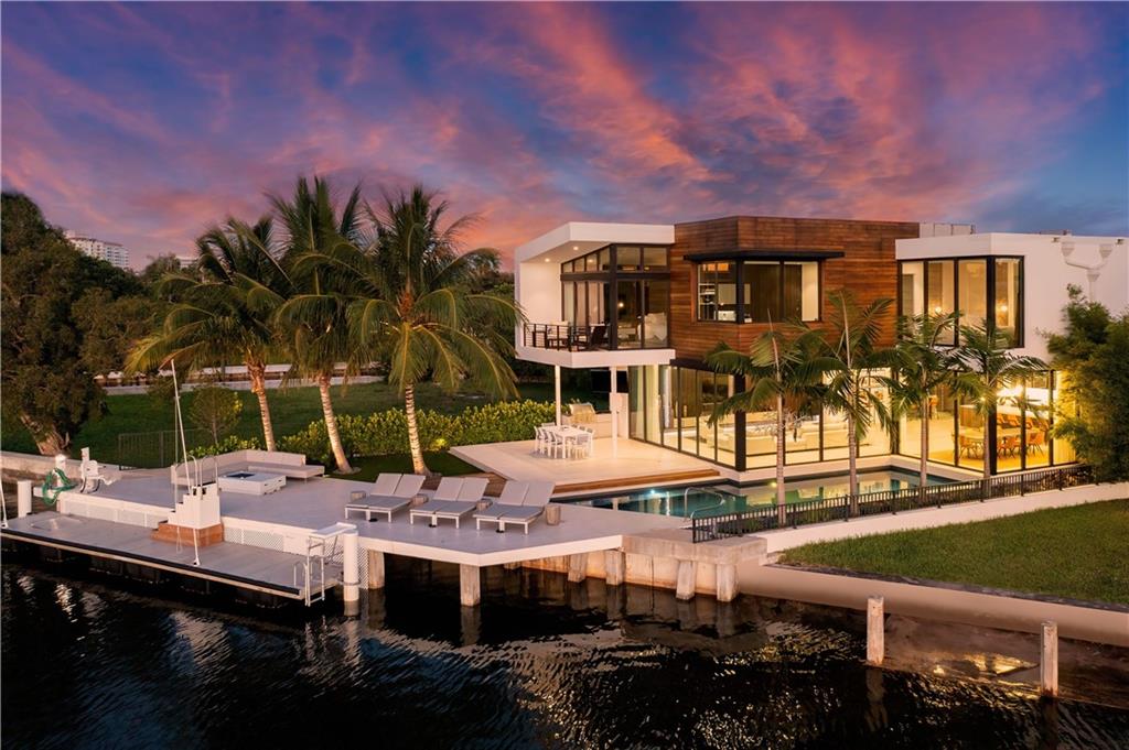 Beautiful modern estate located on Sunset Lake w/ wide water views & easy ocean access! Newer seawall & concrete dock for the avid boater. Open floor plan w/ features that include a wet bar w/ fridge & wine cooler, home theater, kitchen w/ top of the line appliances, gorgeous cabinetry & an extra back kitchen. Light & bright w/ floor to ceiling windows. A floating glass staircase w/ European oak steps leads upstairs to the en-suite guest rooms & large master suite w/ private balcony, dual walk-in closets, water closets & morning bar. Outdoor living space w/ pool, BBQ & fire table. Home is equipped w/ elevator, natural gas, backup generator, custom landscape lighting, 2 laundry rooms & central vacuum system. 3 car garage w/ room for lifts for poss 6 spaces. Furniture negotiable.