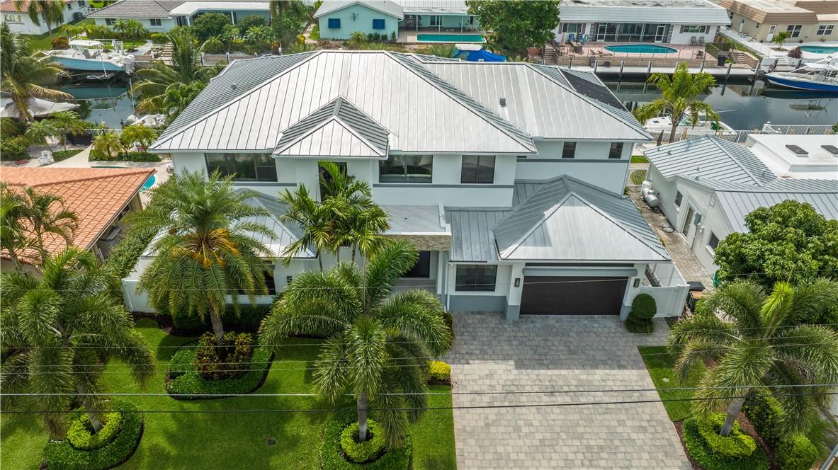 This contemporary newer construction home features 5 bedrooms, 5 full baths, 2 half baths, and an office, located on an island street. The large lanai offers East exposure and comes with an integrated summer kitchen and a hidden automatic screen system. With 85 feet of dockage, the house boasts 12-foot ceilings and 10-foot high impact sliding doors. It's been upgraded with a Savant system, electric blinds, updated electronics, solar pool heating, and a built-in generator. The master bath includes a steam shower and a separate soaking tub. The home is tastefully furnished with high-end furniture and is being sold fully furnished for an easy move. As the original owner has used it as a private vacation home, the property has seen very light use.