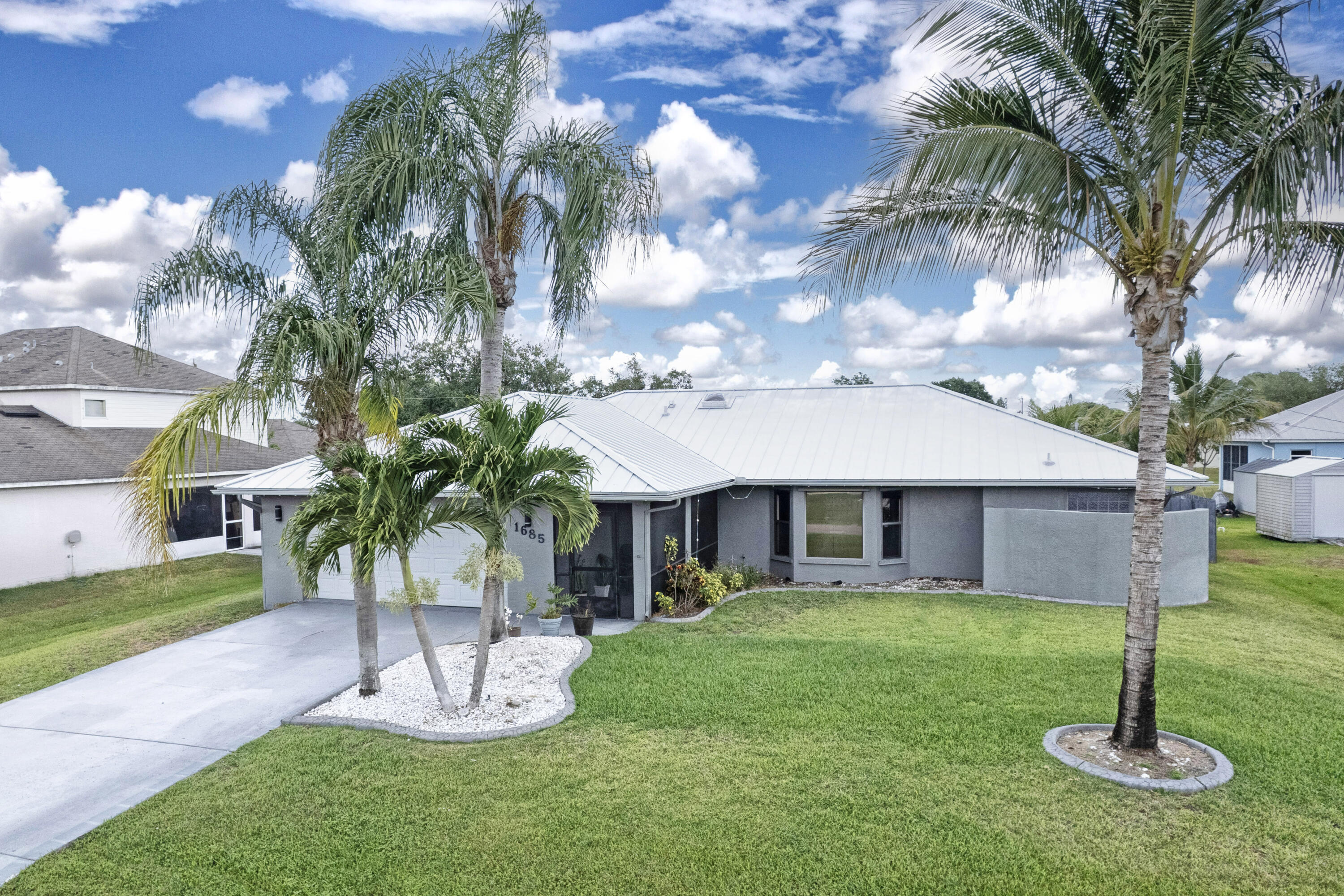 Low cost of living with no HOA fees and lower insurance cost due to new metal roof and CBS construction! This elegantly renovated CBS construction home offers 1,888 sq ft of refined interior space and 2,898 sq ft outdoors. Featuring 3 Bed, 2 Bath, and a 2-car garage, It boasts a 2024 metal roof, 2022 tankless water heater, newer A/C, and full stainless-steel appliance package. The spacious eat-in kitchen includes a pass-thru window, while the expansive screened lanai opens from both the master and guest suites. The luxurious primary suite offers a dual-head shower, spacious walk-in closet, and private lanai access. Laundry room includes washer, dryer, and tub. High-end ceiling fans throughout. Fully fenced yard with space for a pool and toys. Click "more' to keep reading ... It is in a prime location convenient to shops, major highways, minutes to the beach a public boat launch.